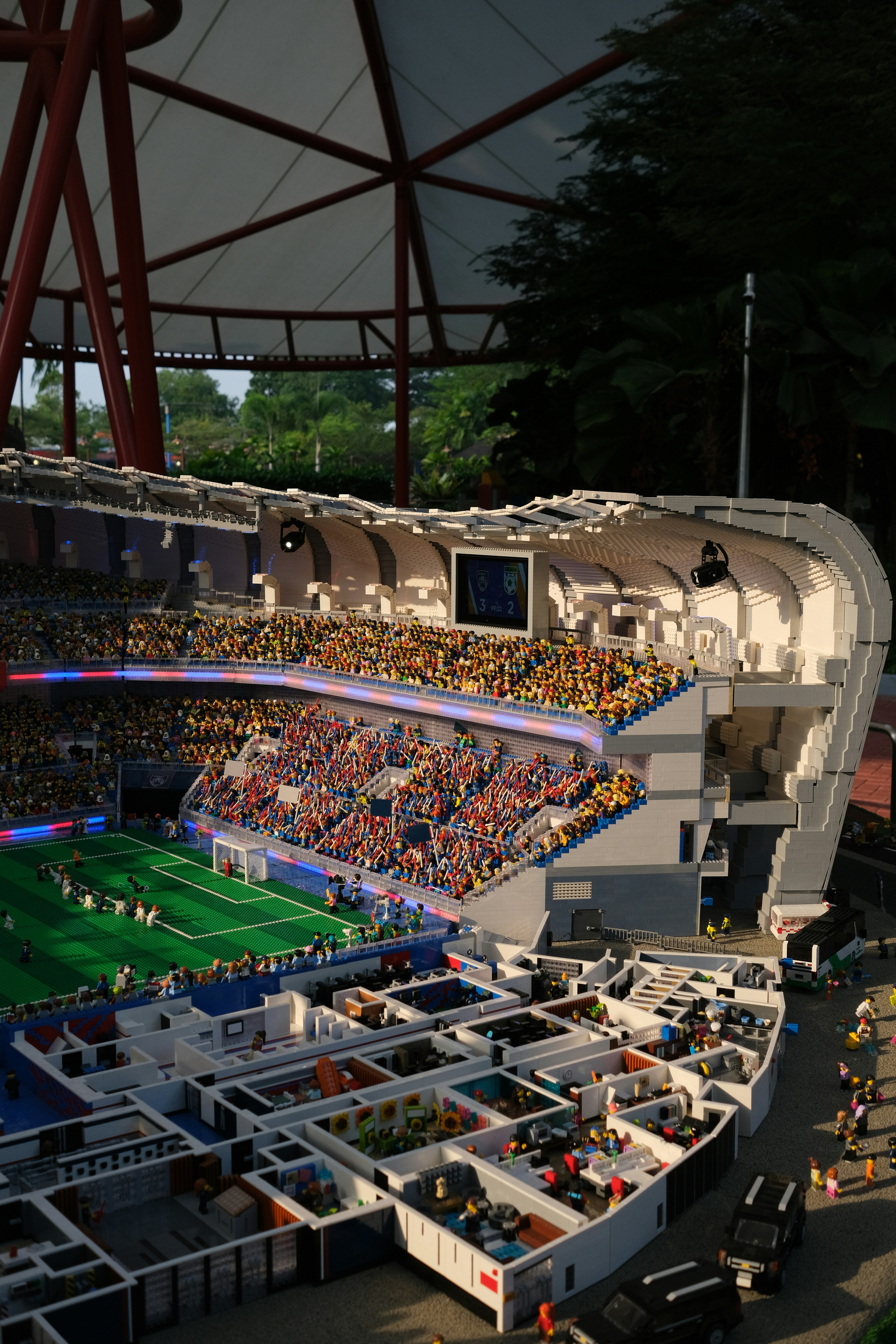 Un modèle de stade Lego avec un match de football et des pièces intérieures détaillées