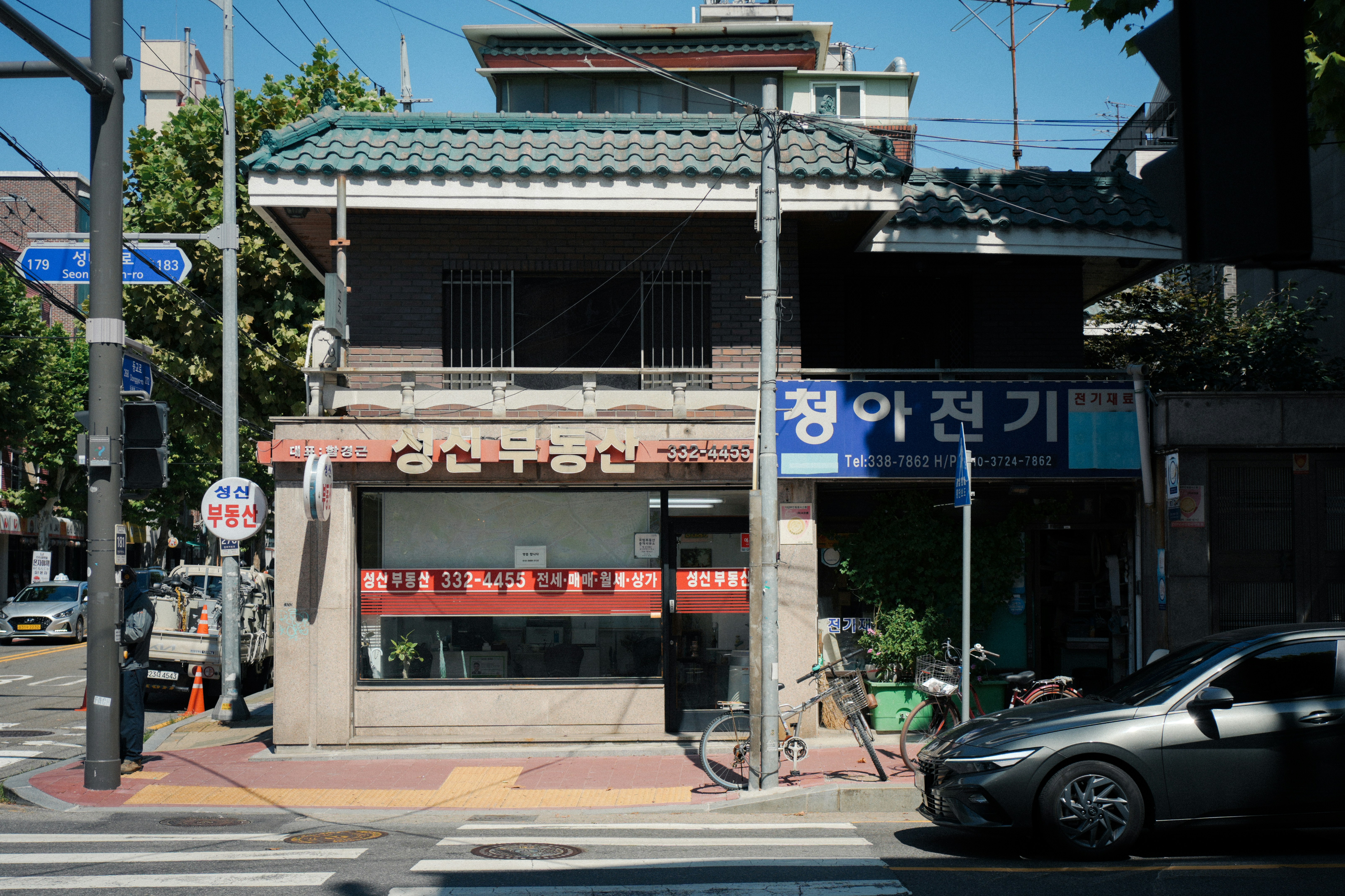 A two-story building with storefronts on a street corner in Seoul