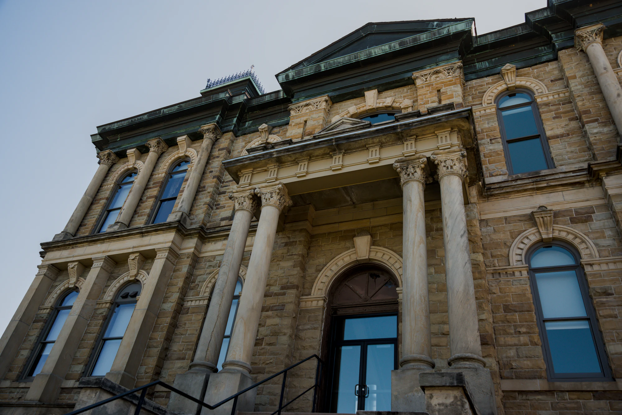 Stone courthouse facade with columns and arched windows