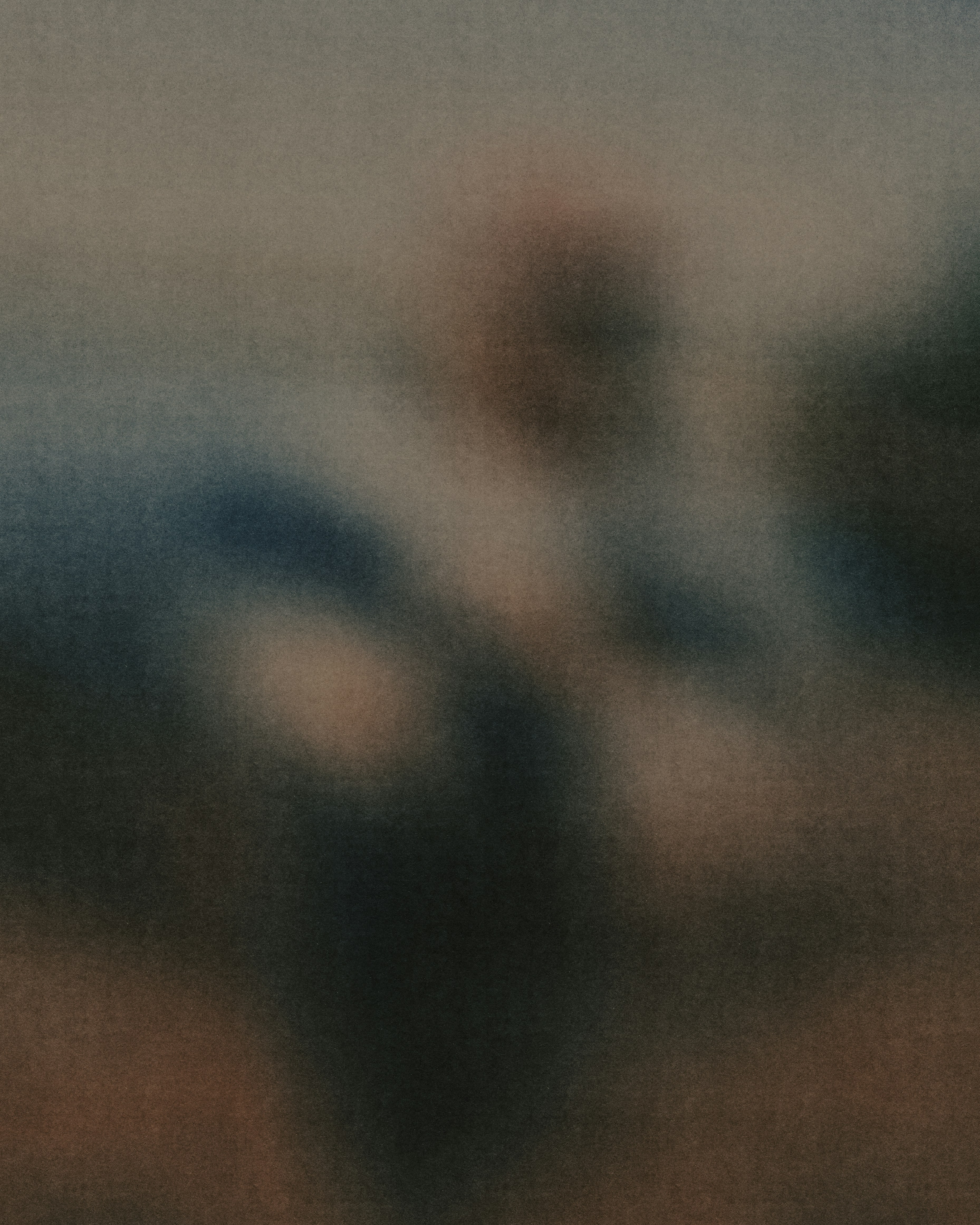 Abstract blurred shapes in muted tones of brown, blue, and grey