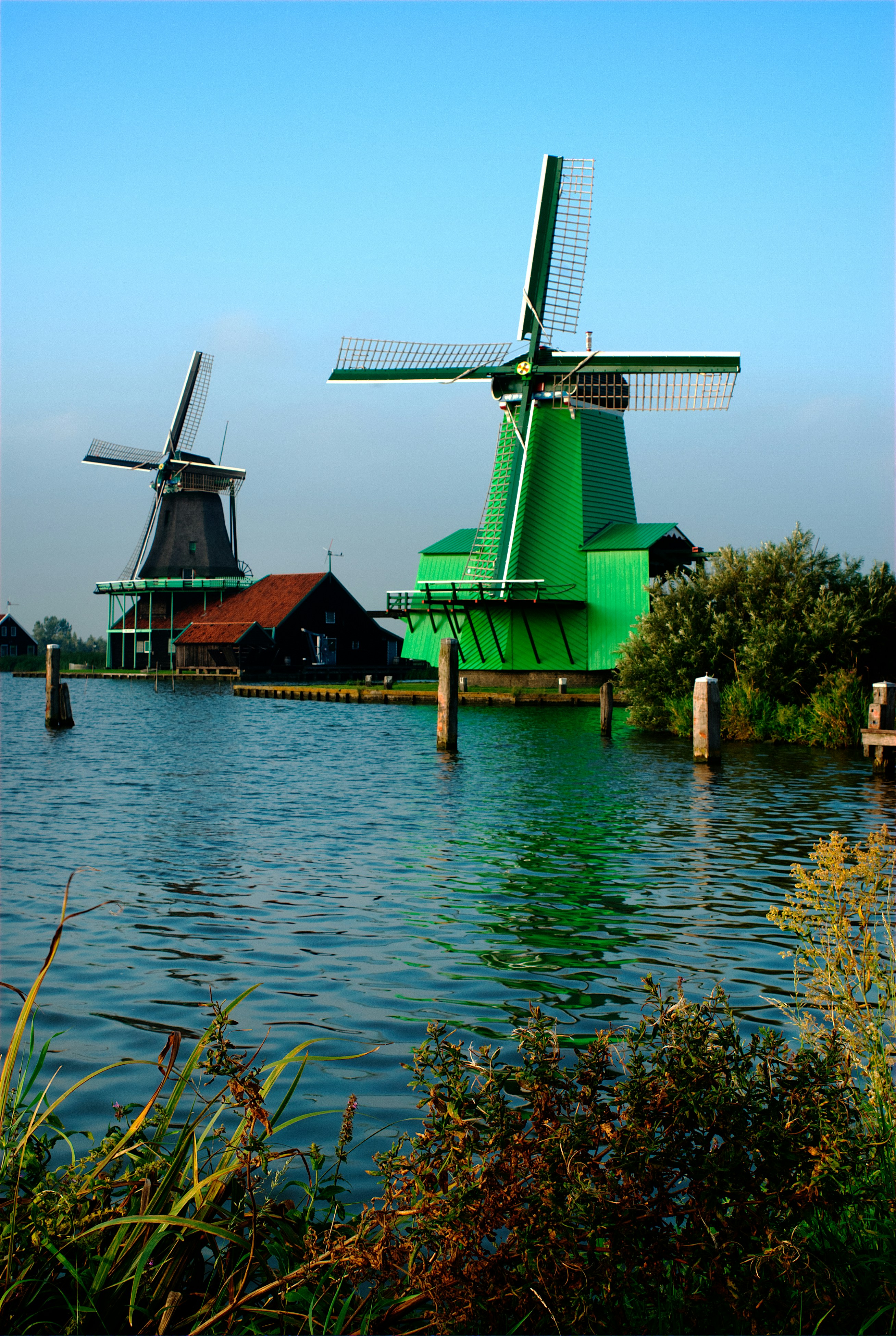 Two traditional windmills on the water in Zaanse Schans, Netherlands