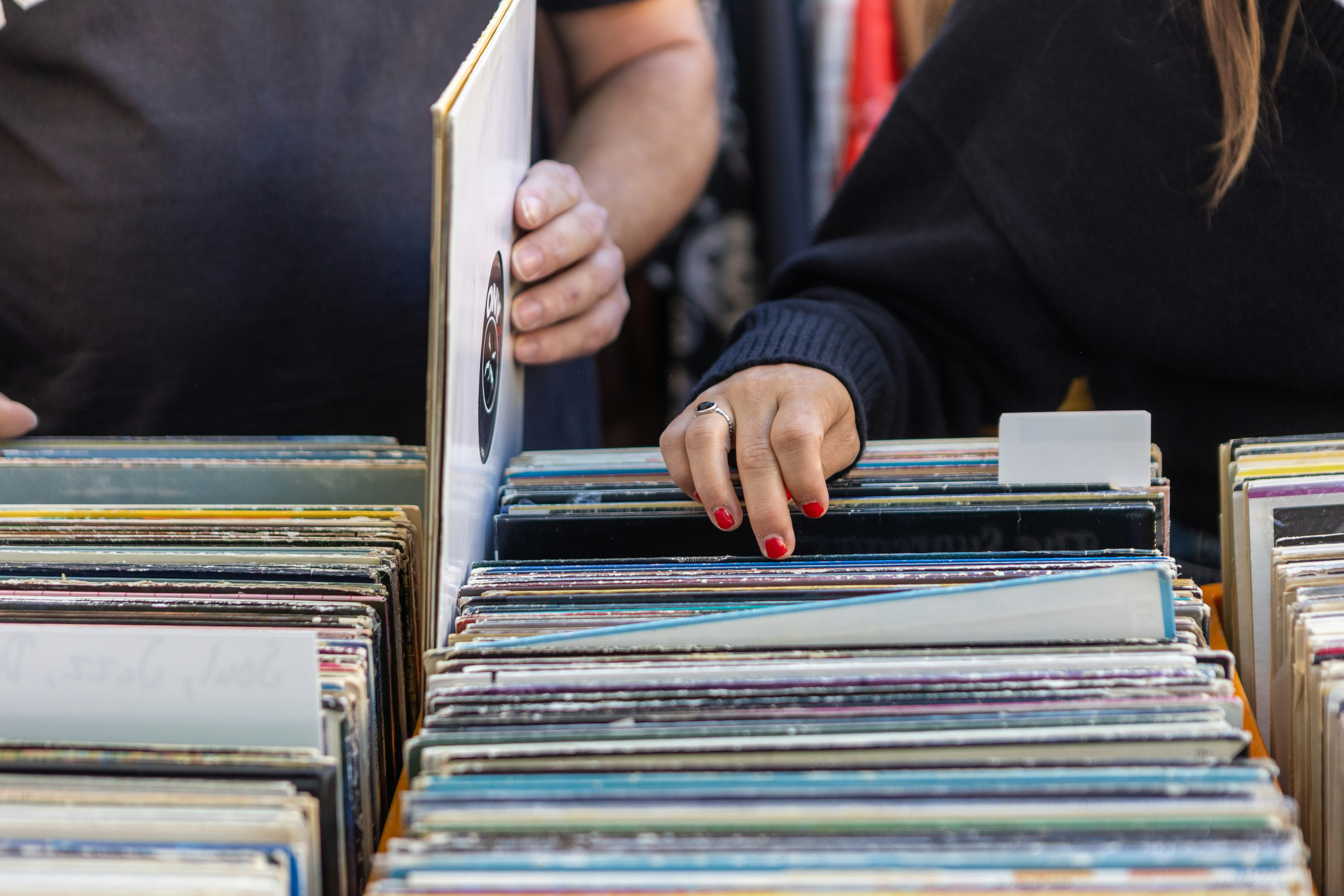 Two people browsing through a crate of vinyl records