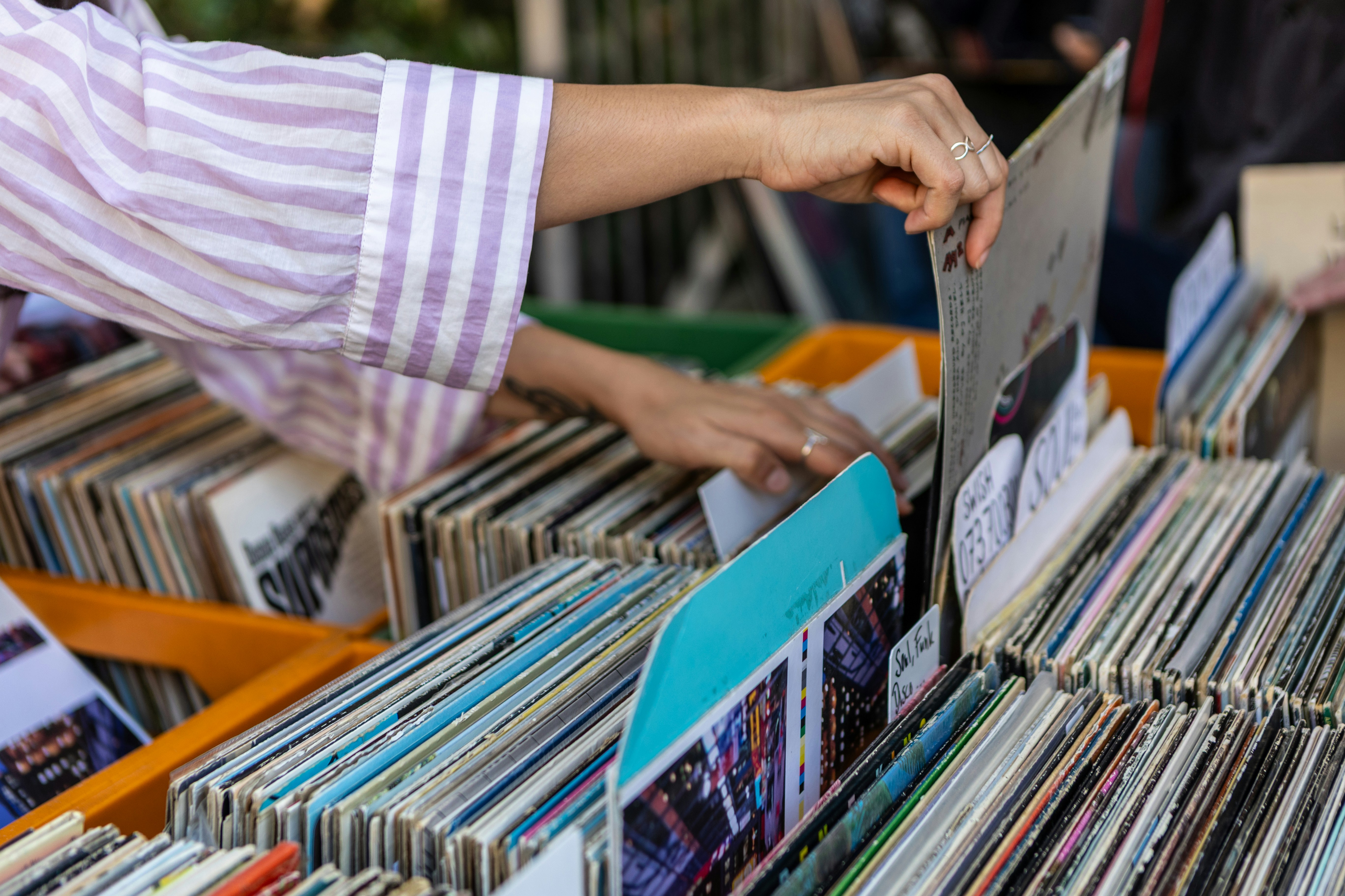Person in a striped shirt flipping through vinyl