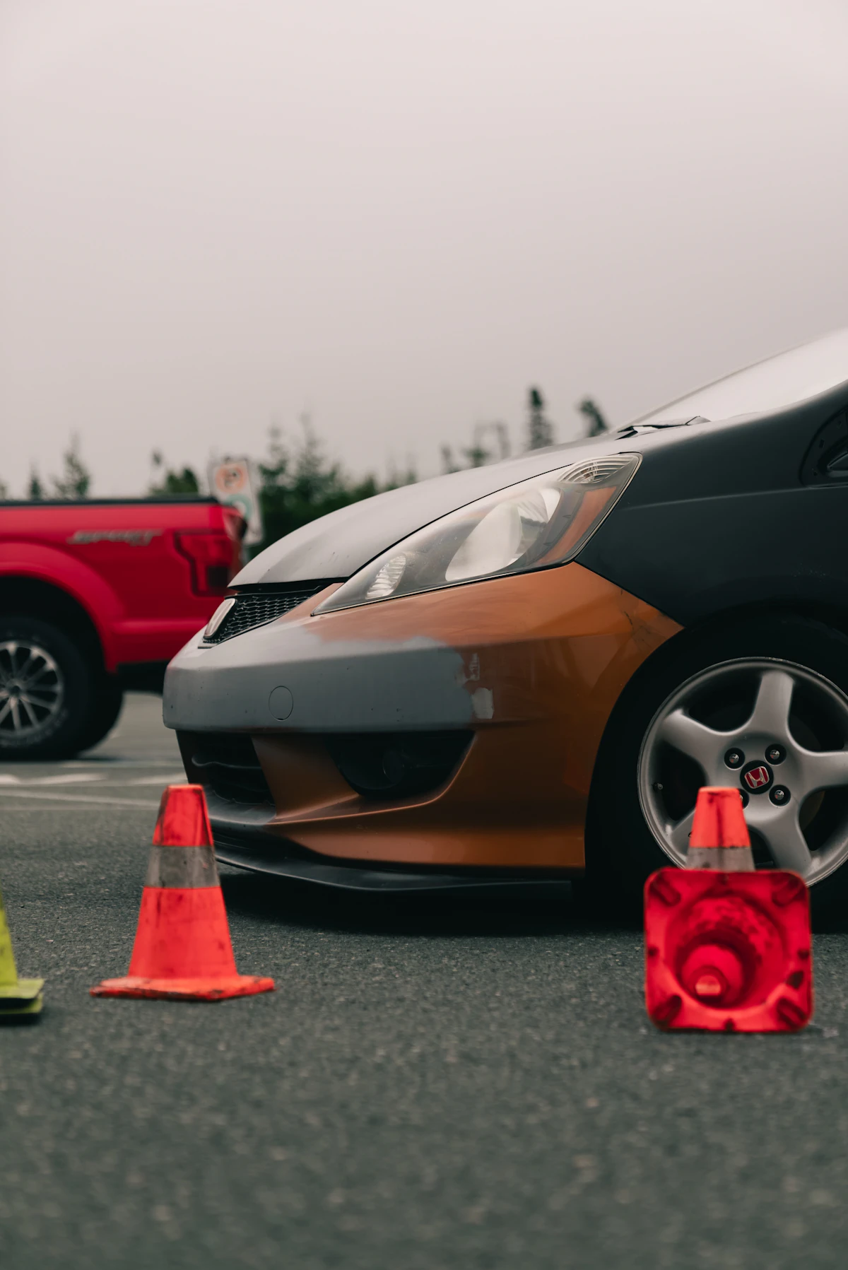 Mobil dengan bumper tidak serasi di tempat parkir