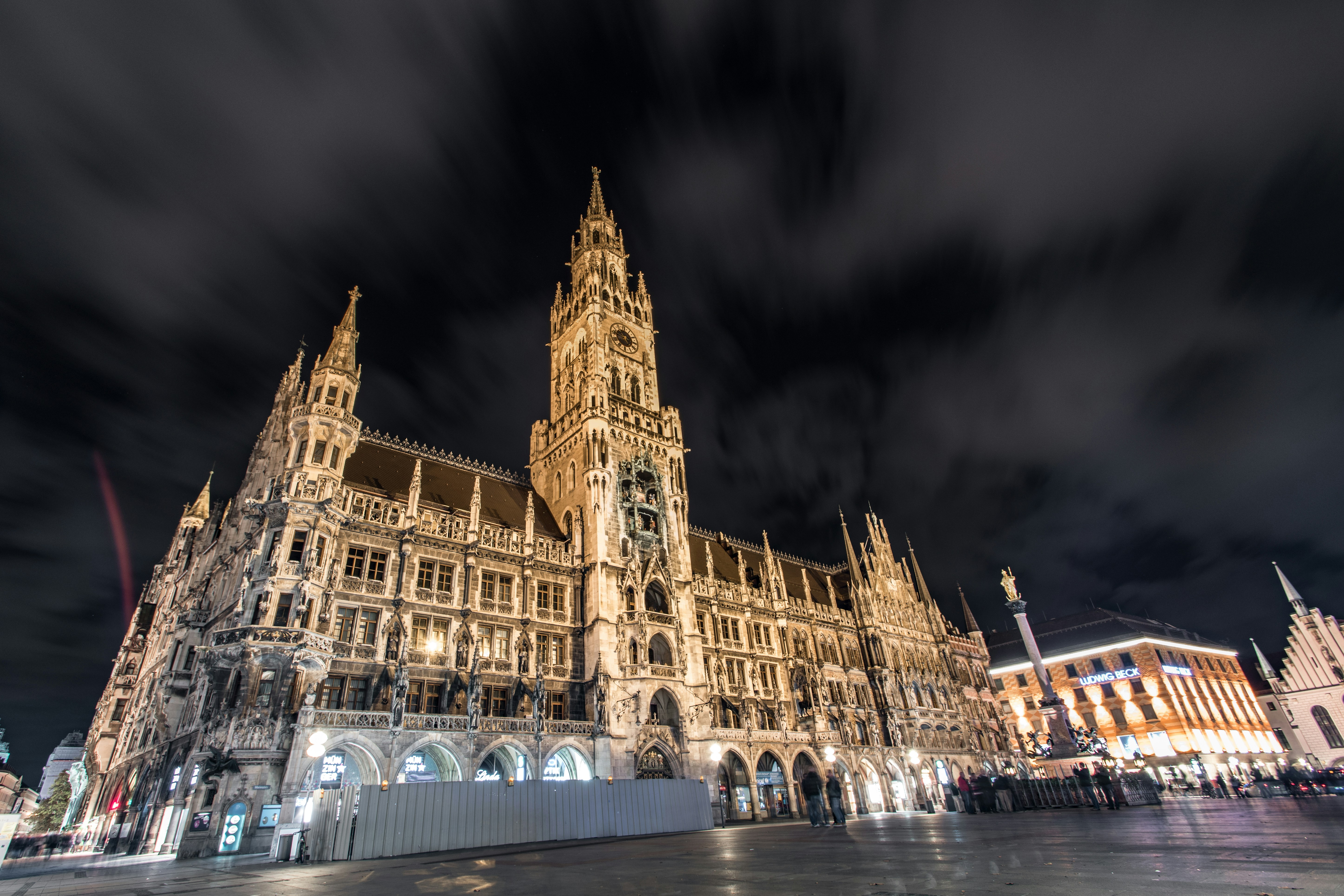 Das Neue Rathaus in München nachts unter einem wolken, dunklen Himmel