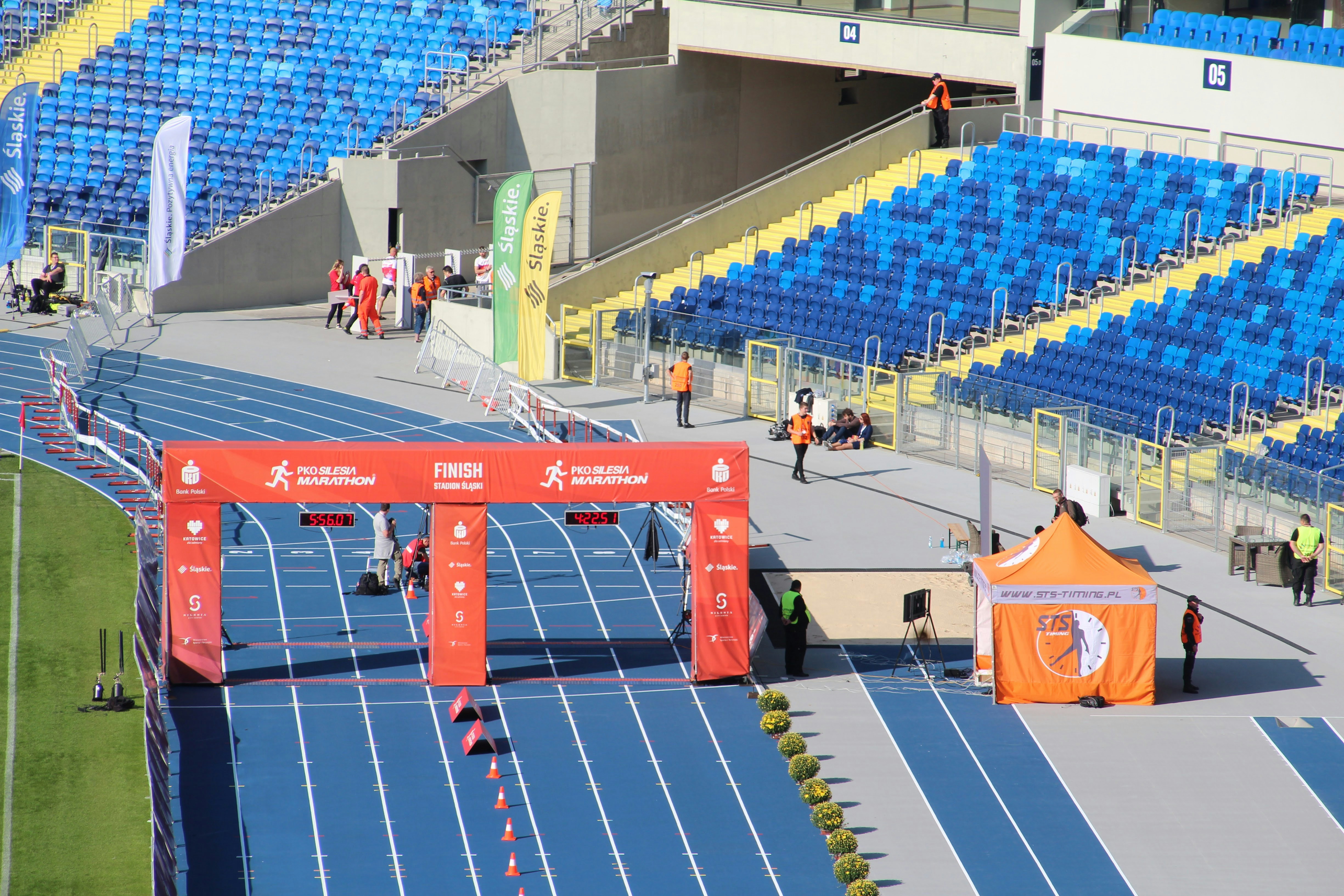 A red finish line arch on a blue running track at a stadium