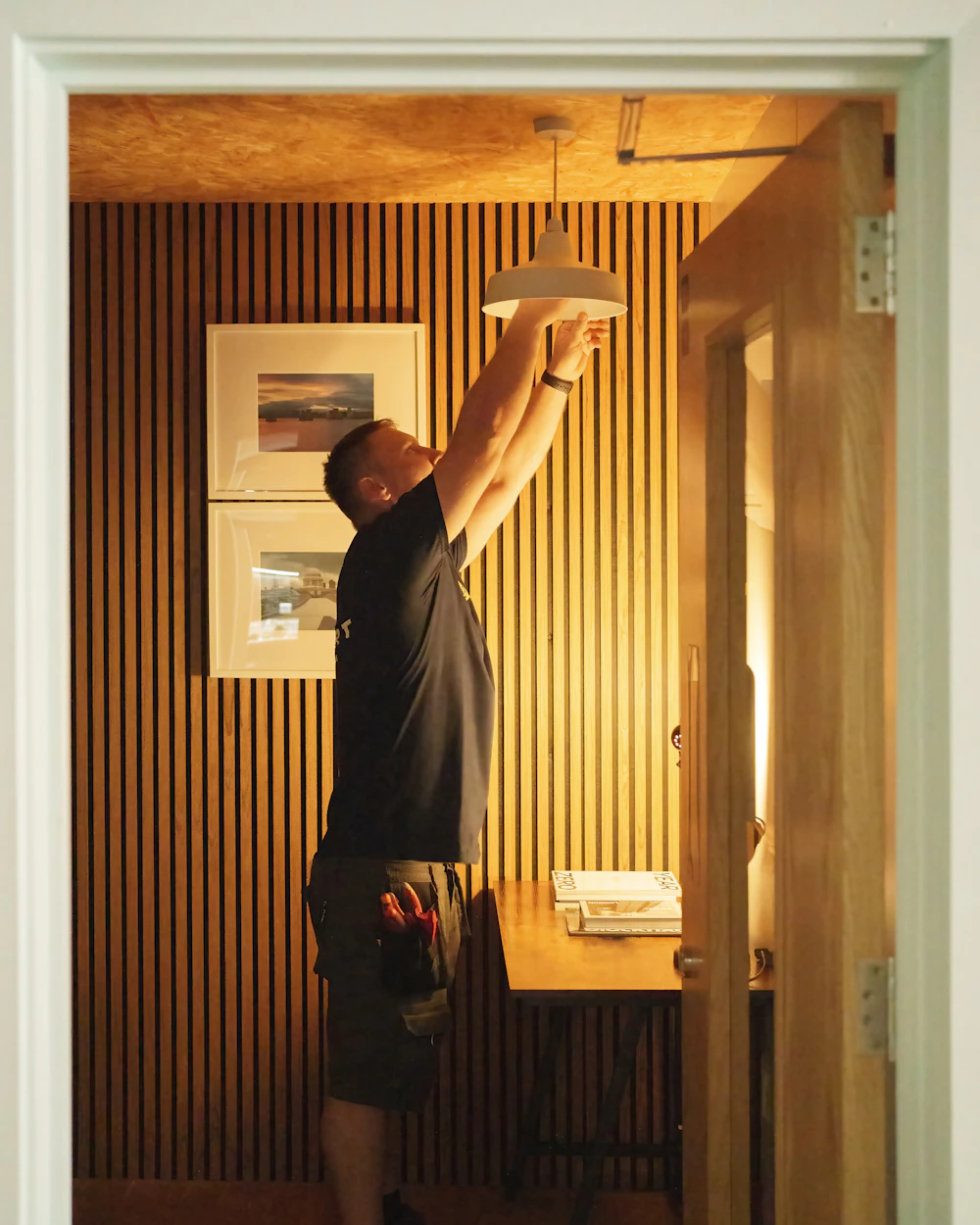 Profissional de manutenção instalando luminária em apartamento