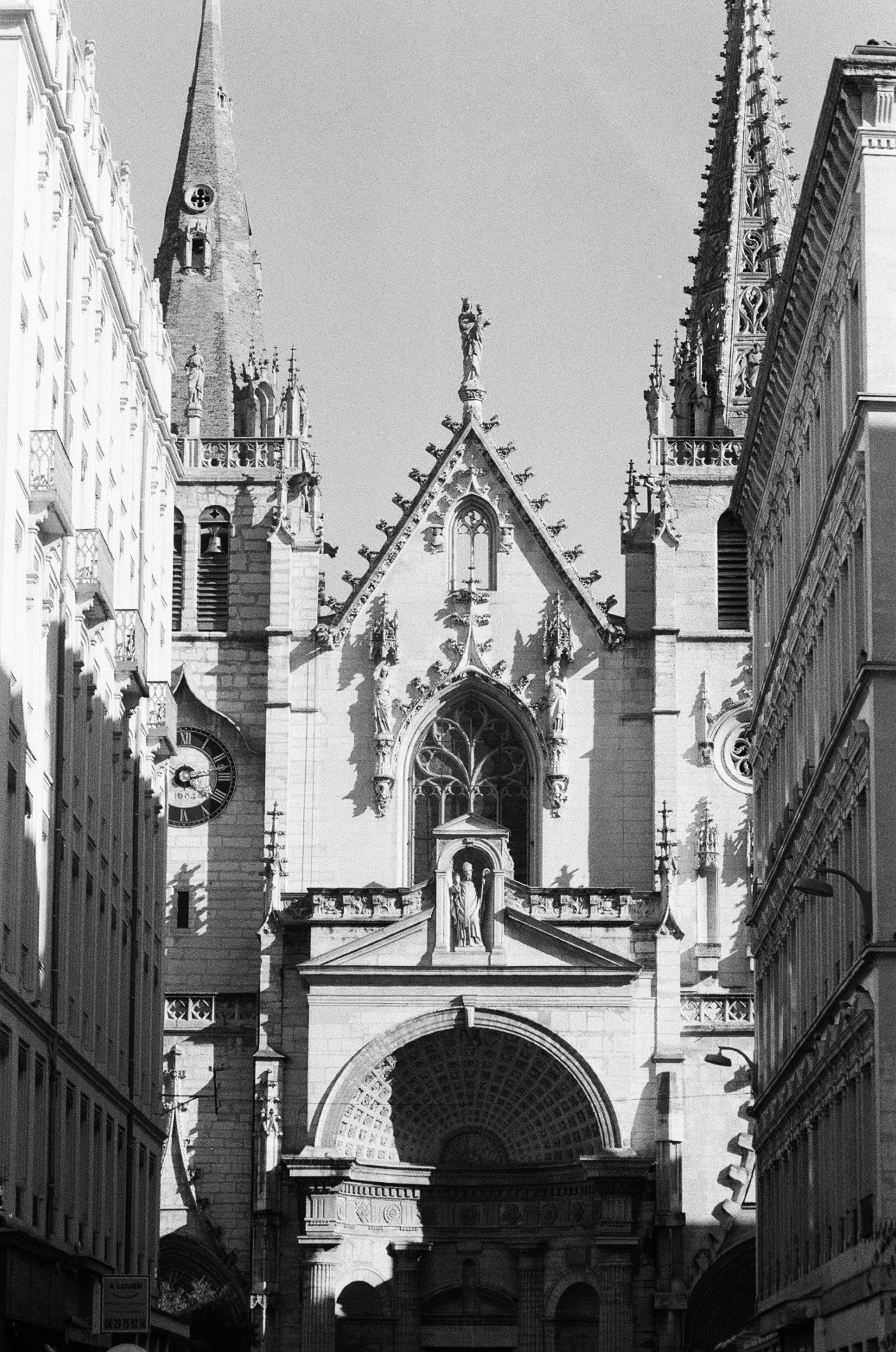 The gothic facade of Saint-Nizier church framed by tall residential buildings in Lyon