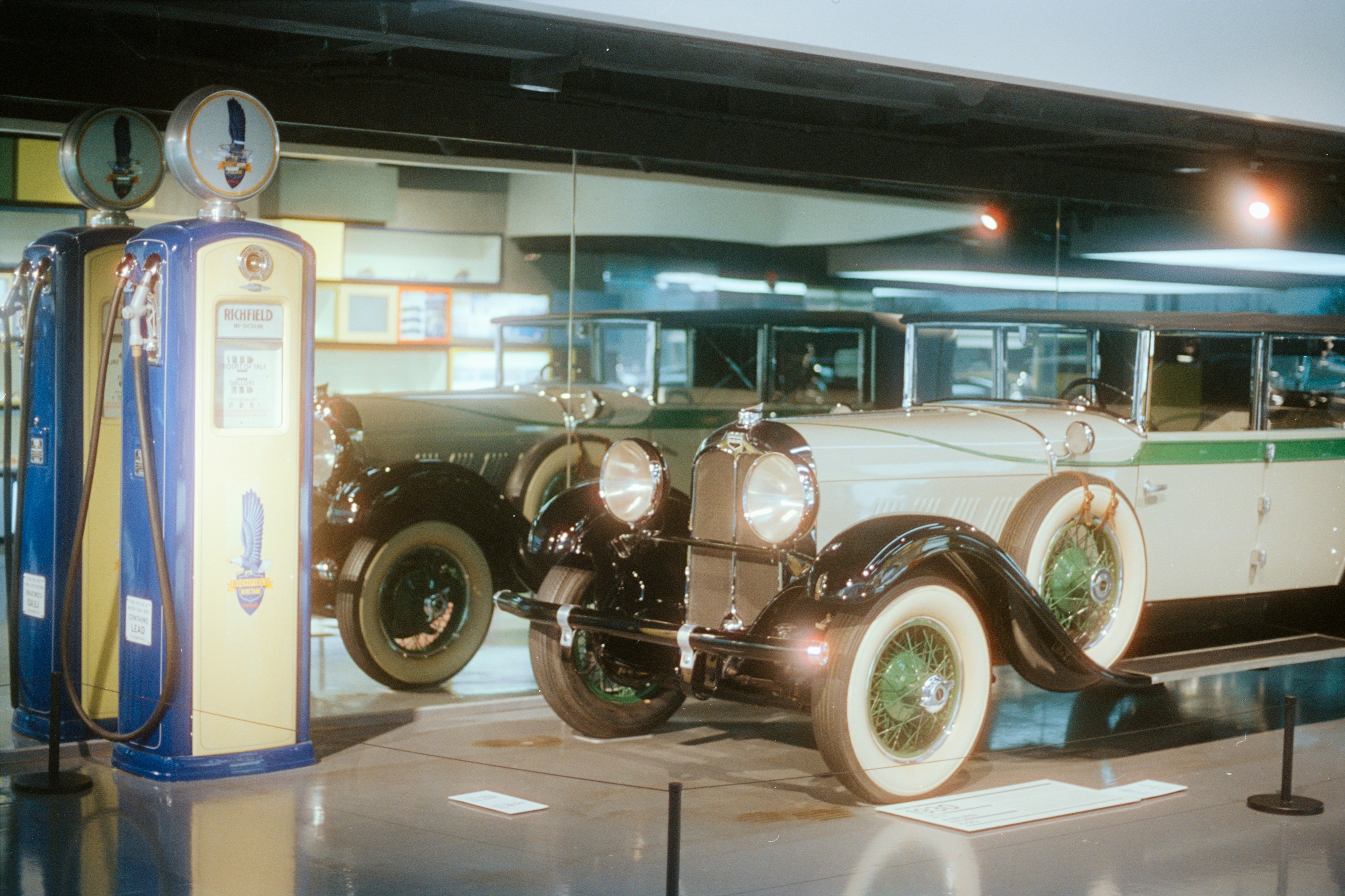 A vintage car parked beside a retro fuel pump - historic gas stations