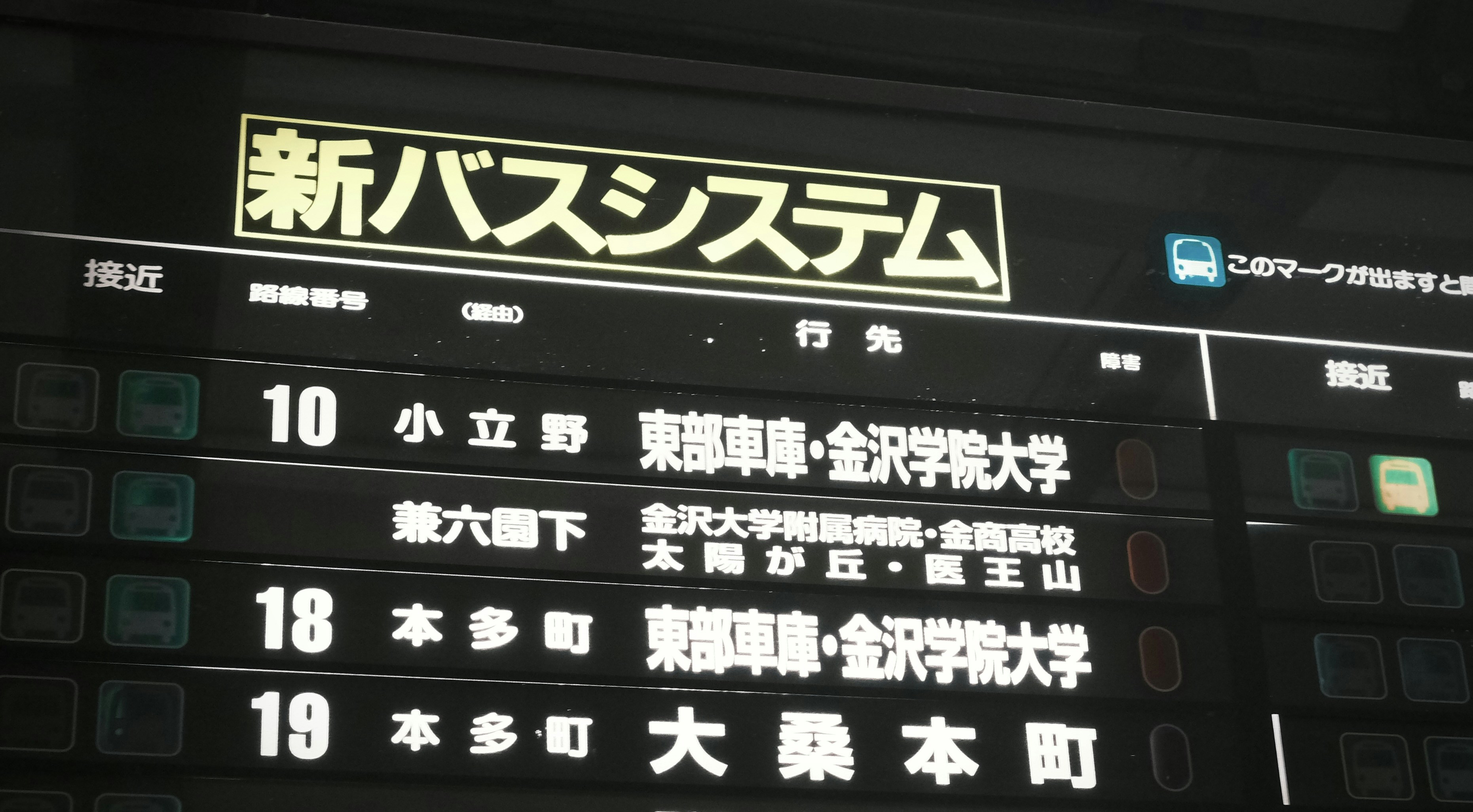 A digital bus arrival information display with Japanese text in Kanazawa