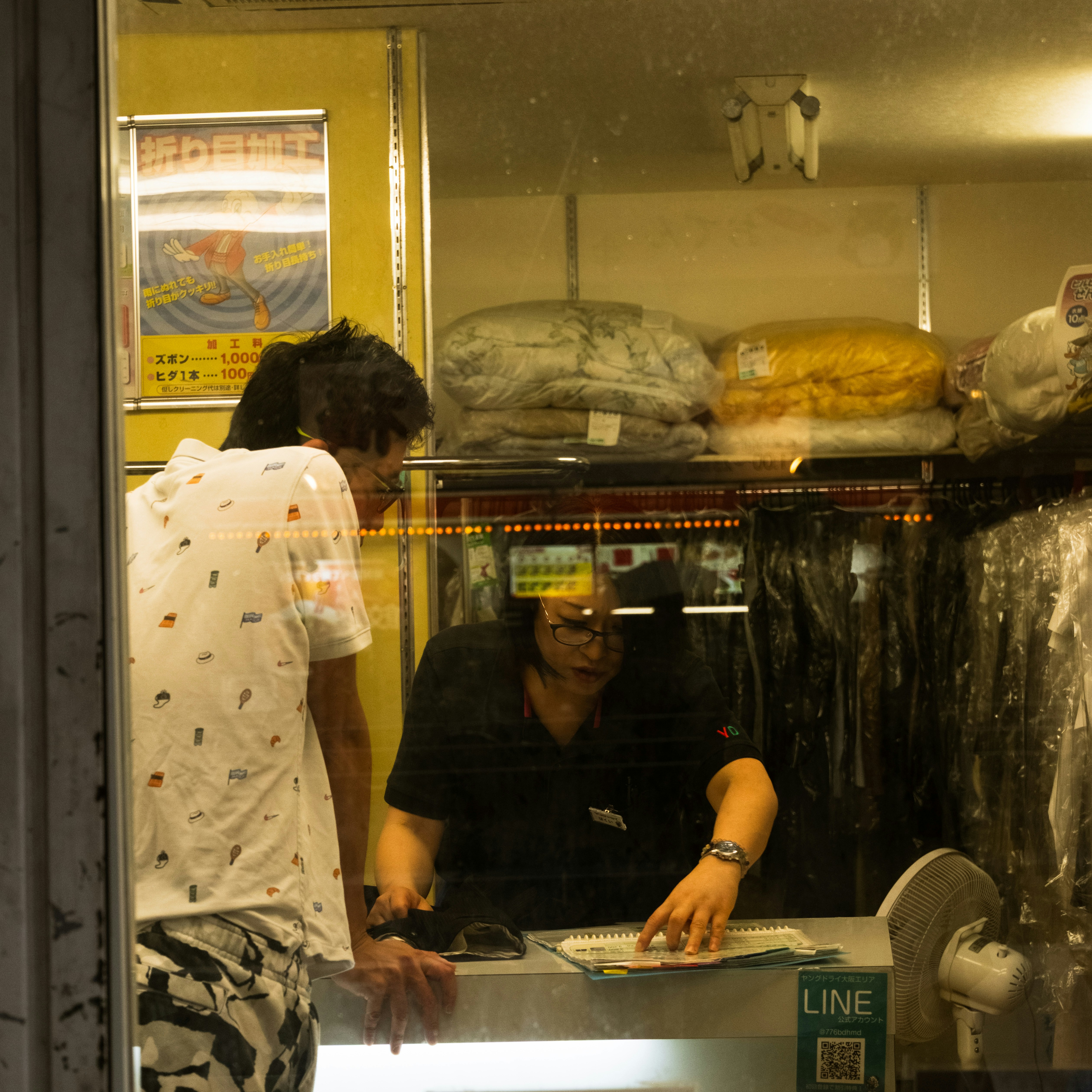 A customer at the counter of a dry cleaner