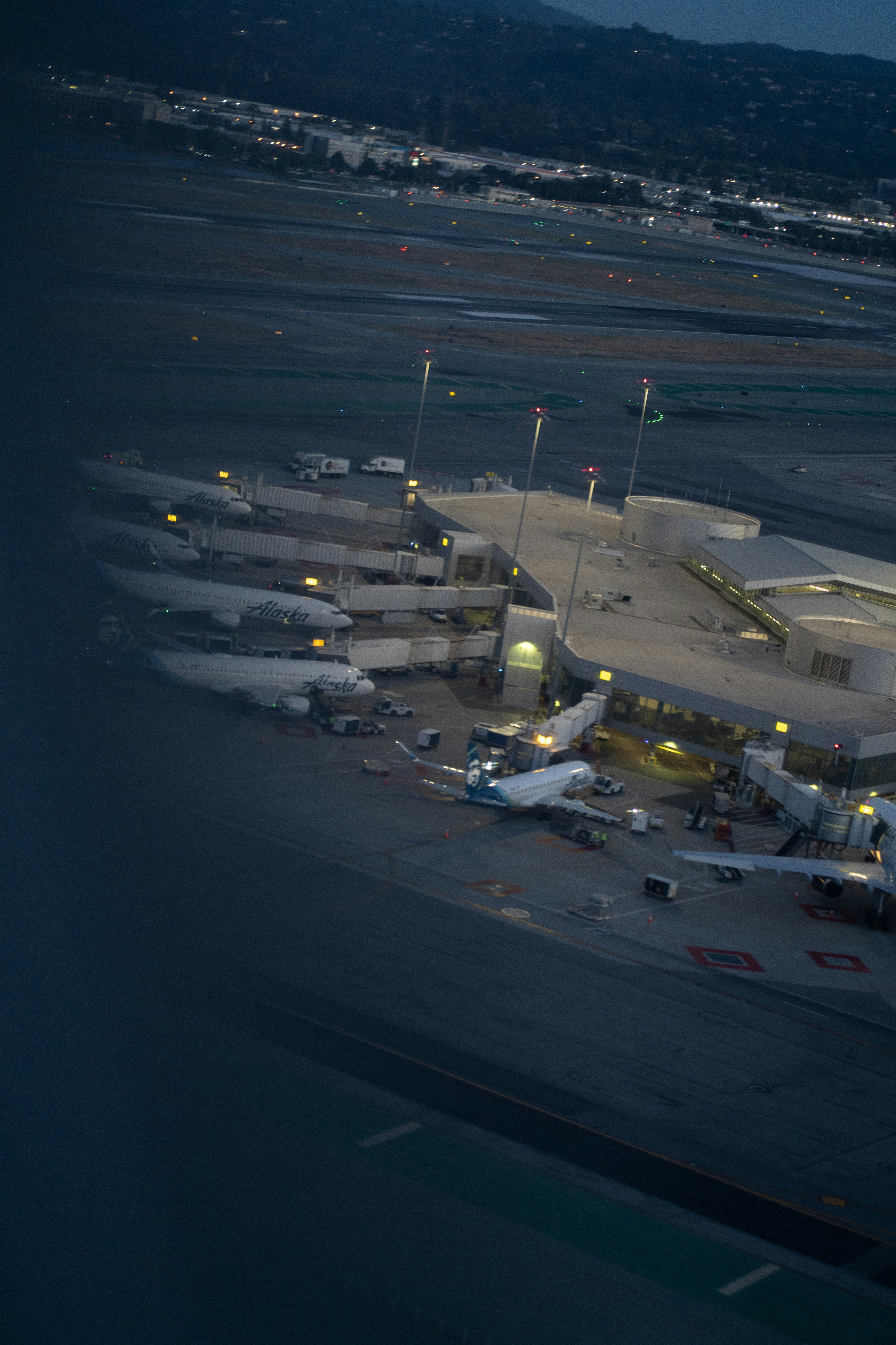 Luftaufnahme von Alaska Airlines Flugzeugen, die nachts an einem Flughafenterminal geparkt sind