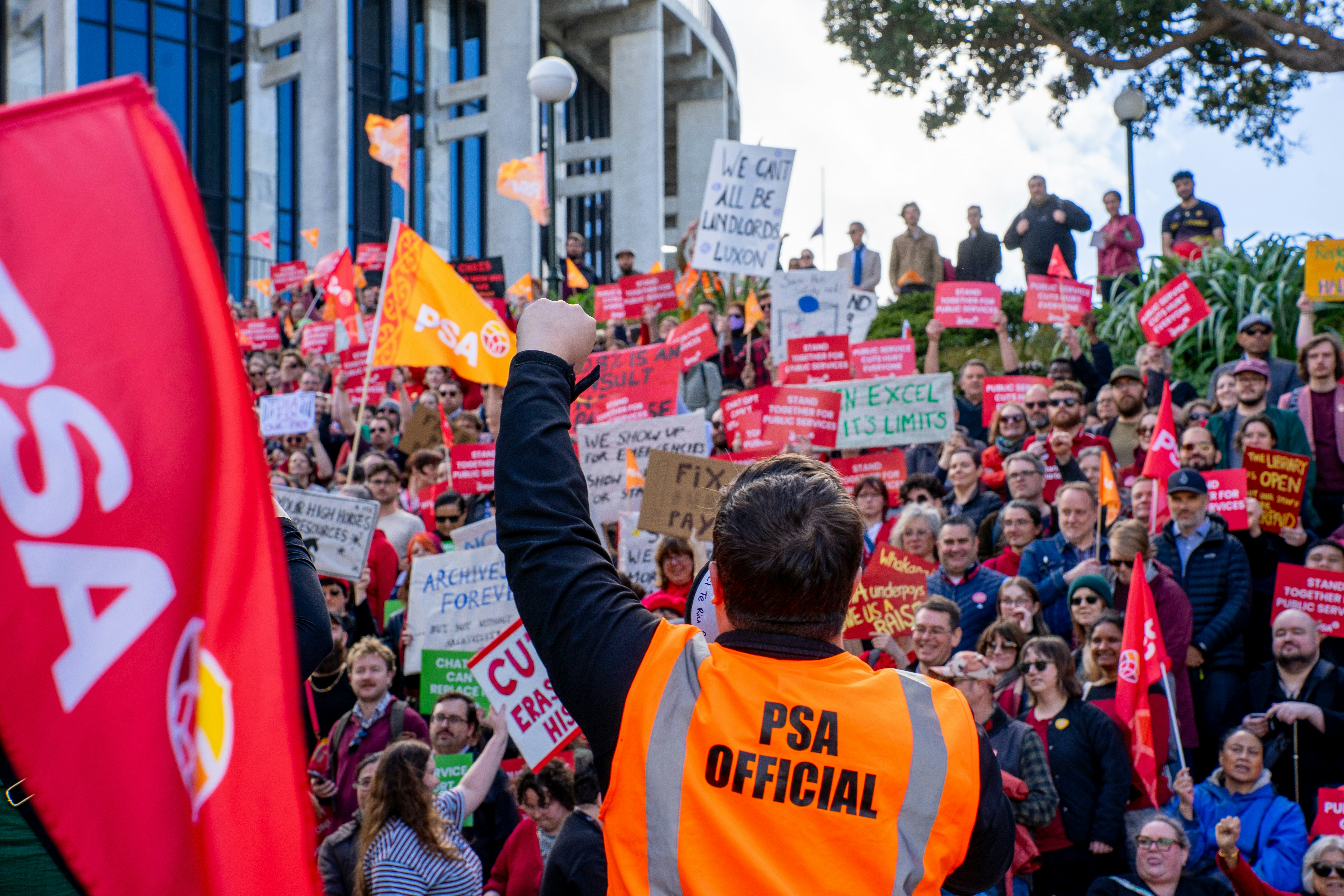 Why Fiscal Consolidation Is a Paradox for the Far Right — A person in an orange vest with a raised fist at a public protest