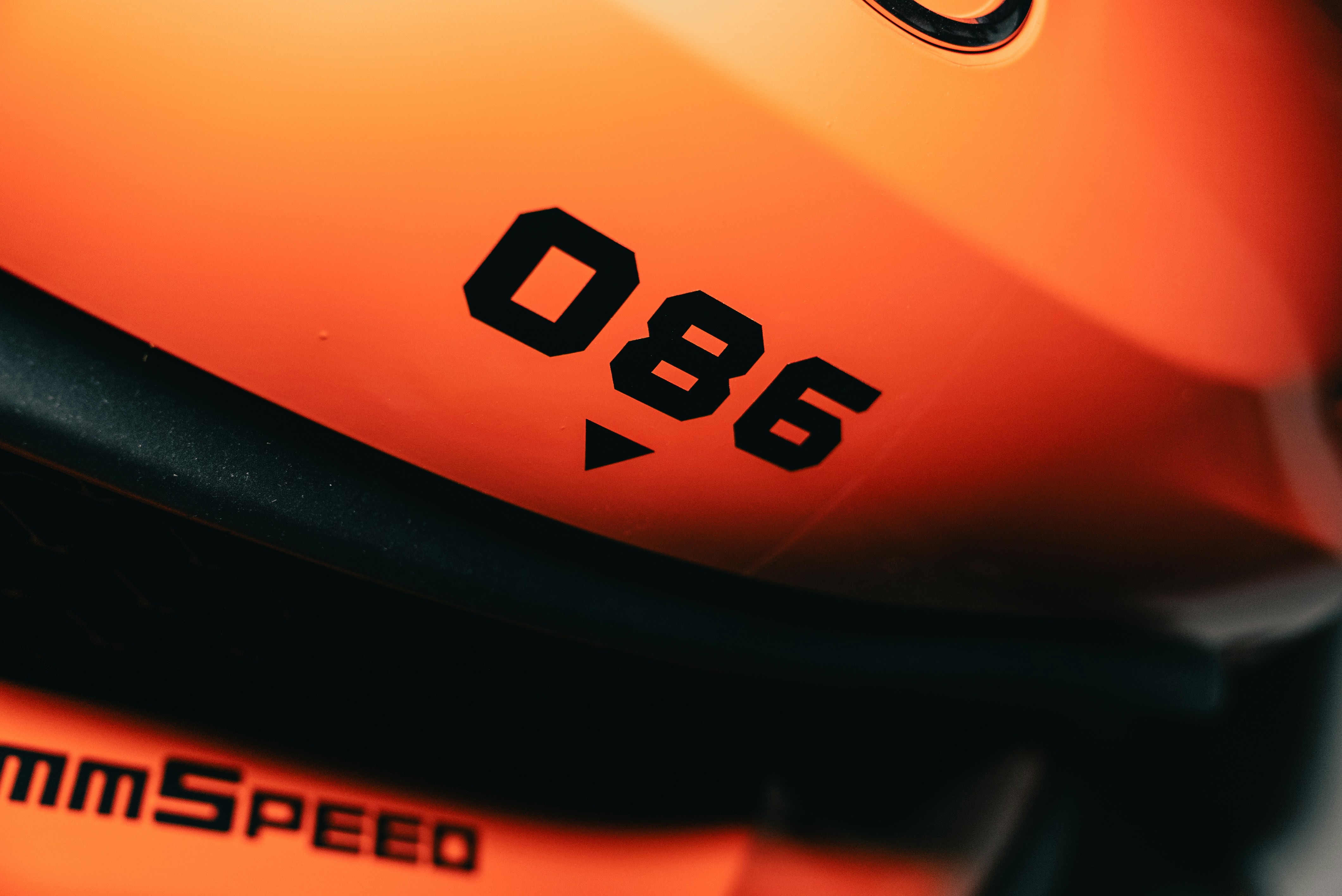 The number 086 and the word mmSPEED printed in black on an orange surface