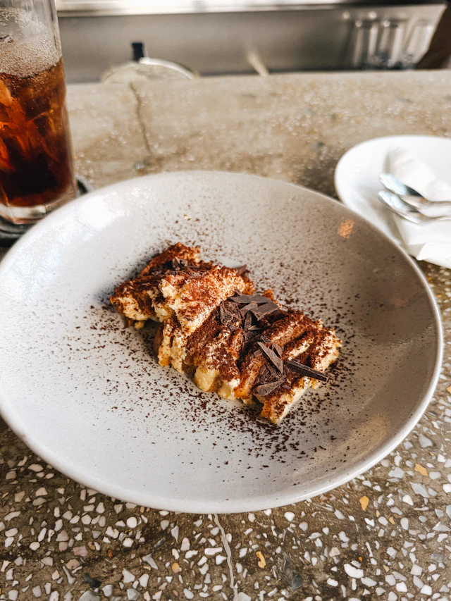 A slice of tiramisu dusted with cocoa