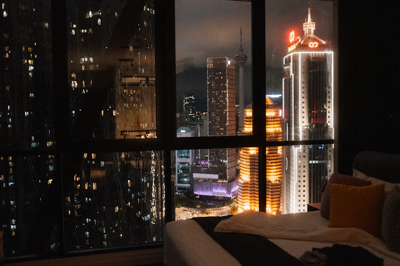 A city skyline at night seen from a dim hotel room