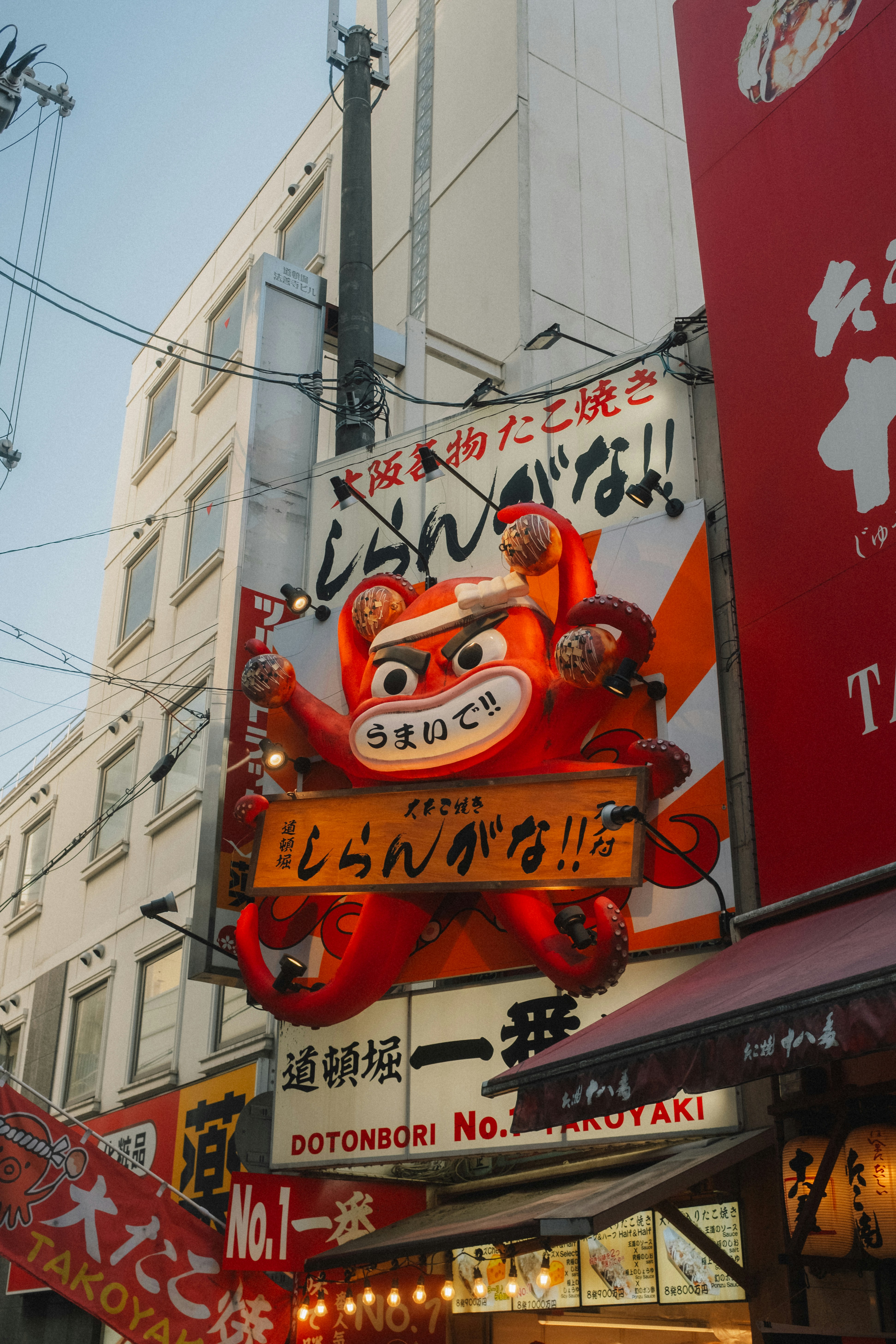 A large red octopus mascot sign on a building in the Dotonbori district
