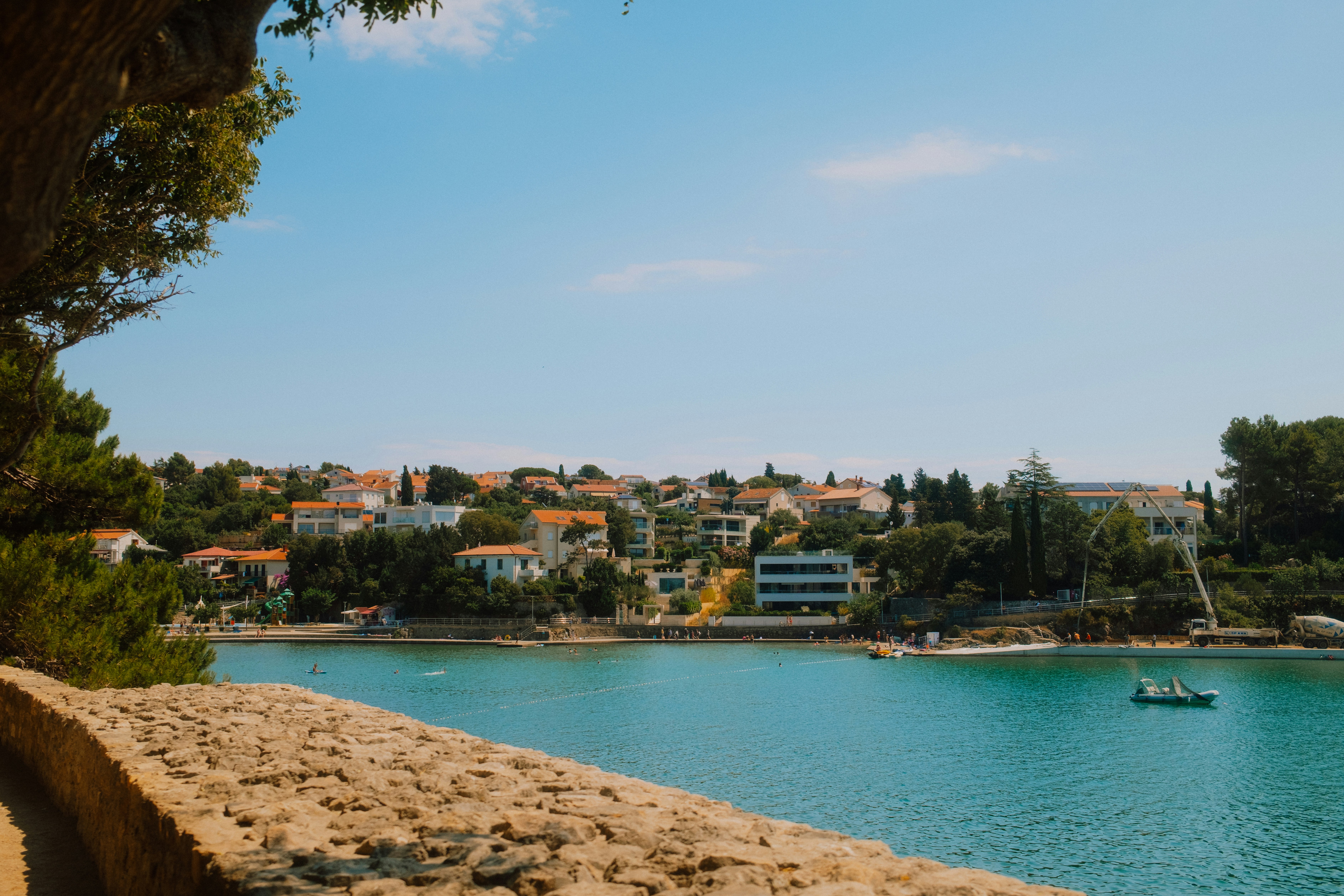 A coastal town with orange-roofed houses overlooking a turquoise bay