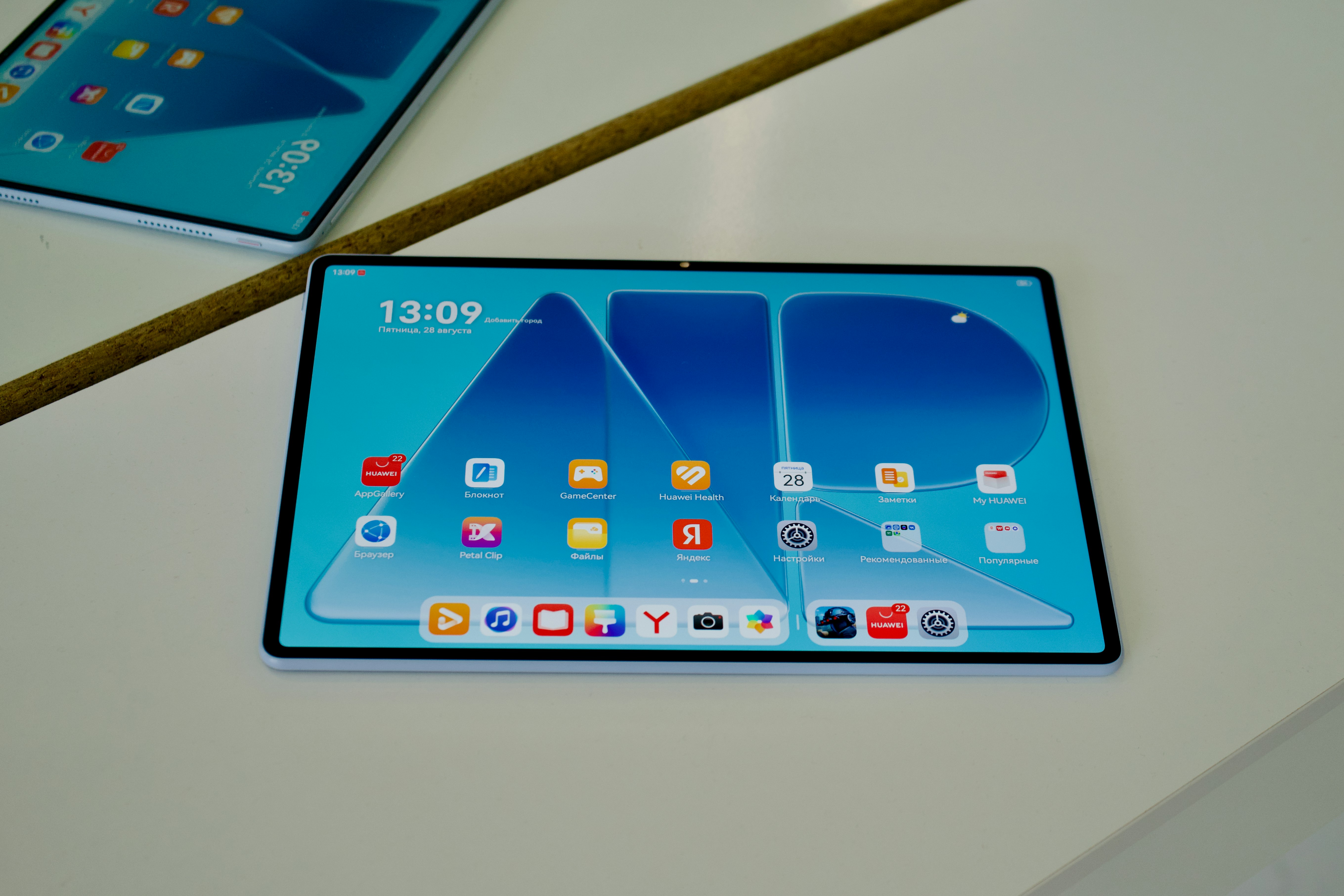Dois tablets com telas iniciais azuis sobre uma superfície branca