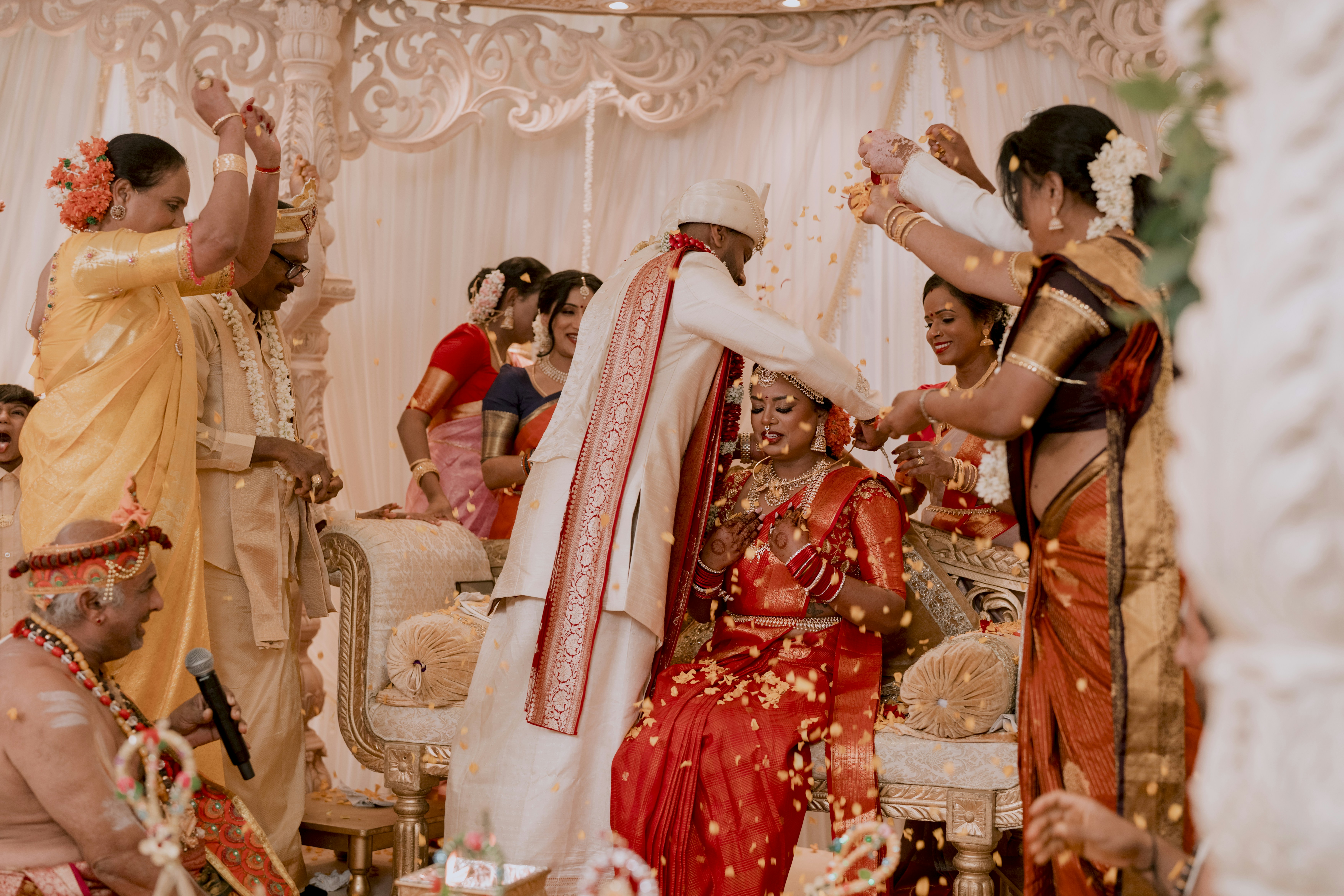 Photo of A groom placing a veil on a bride during a traditional Indian wedding ceremony by Sabesh Photography LTD