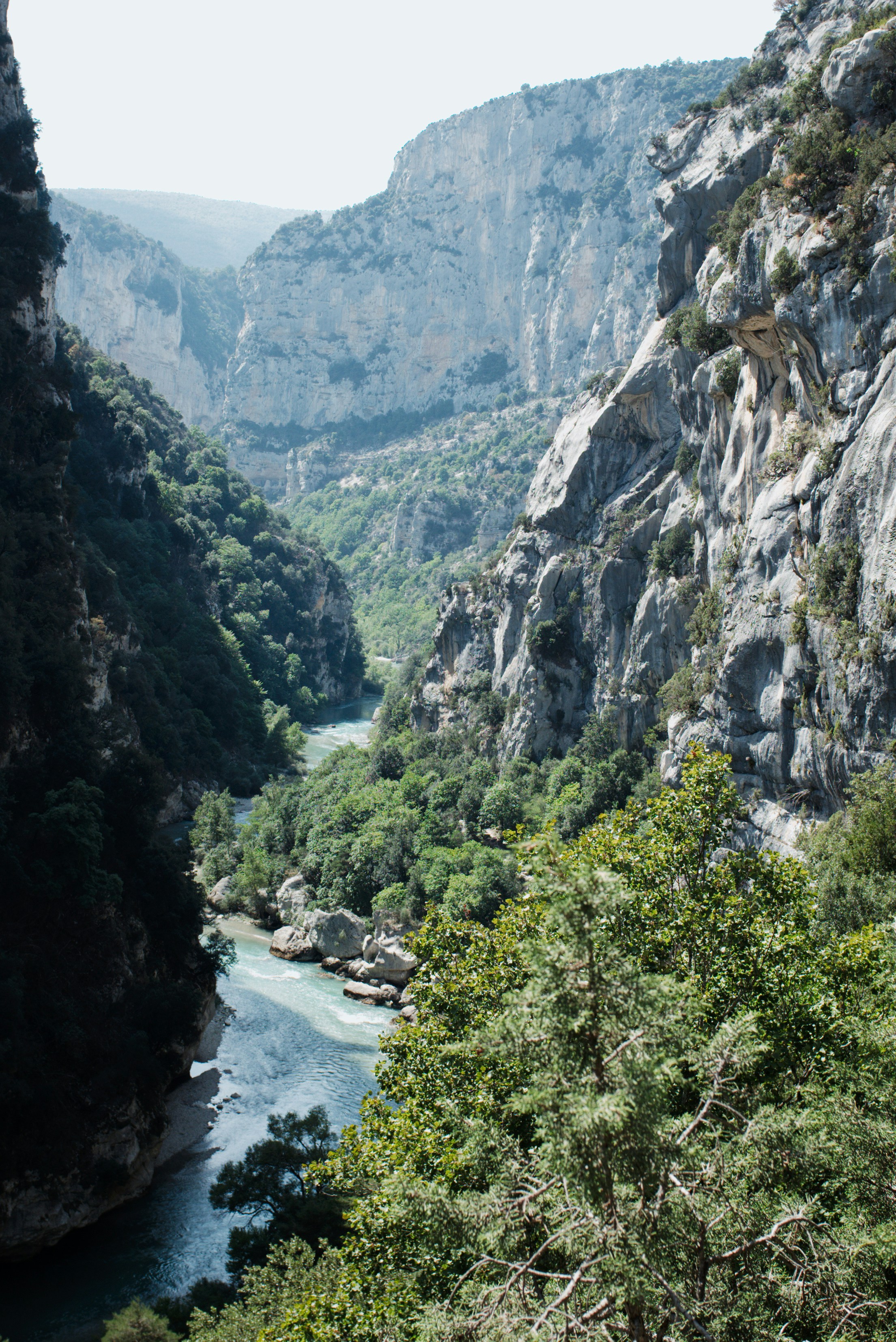 Un fiume turchese che scorre attraverso un profondo canyon calcareo con ripide scogliere rocciose