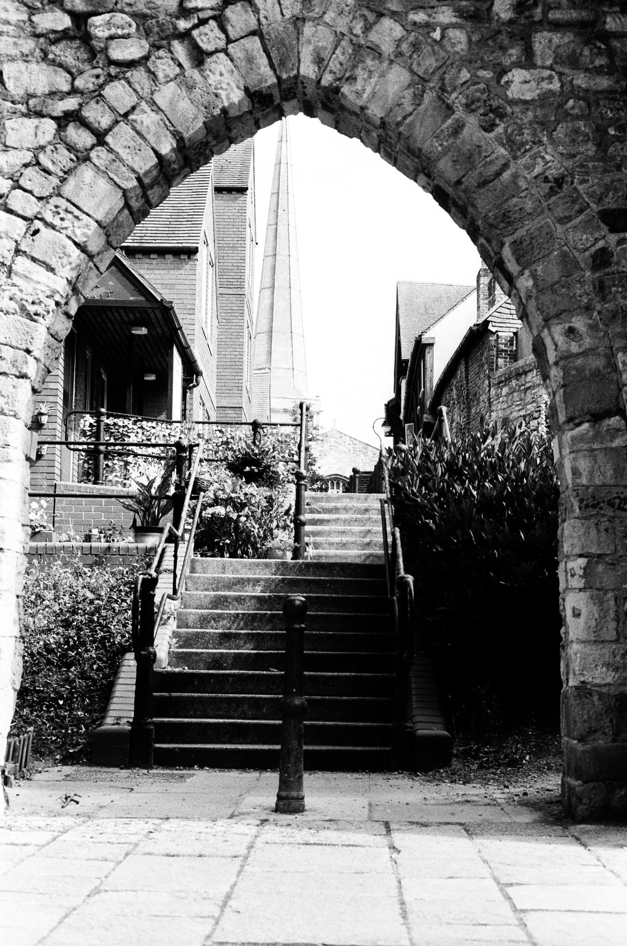 Stone archway framing a set of stairs leading to a church spire