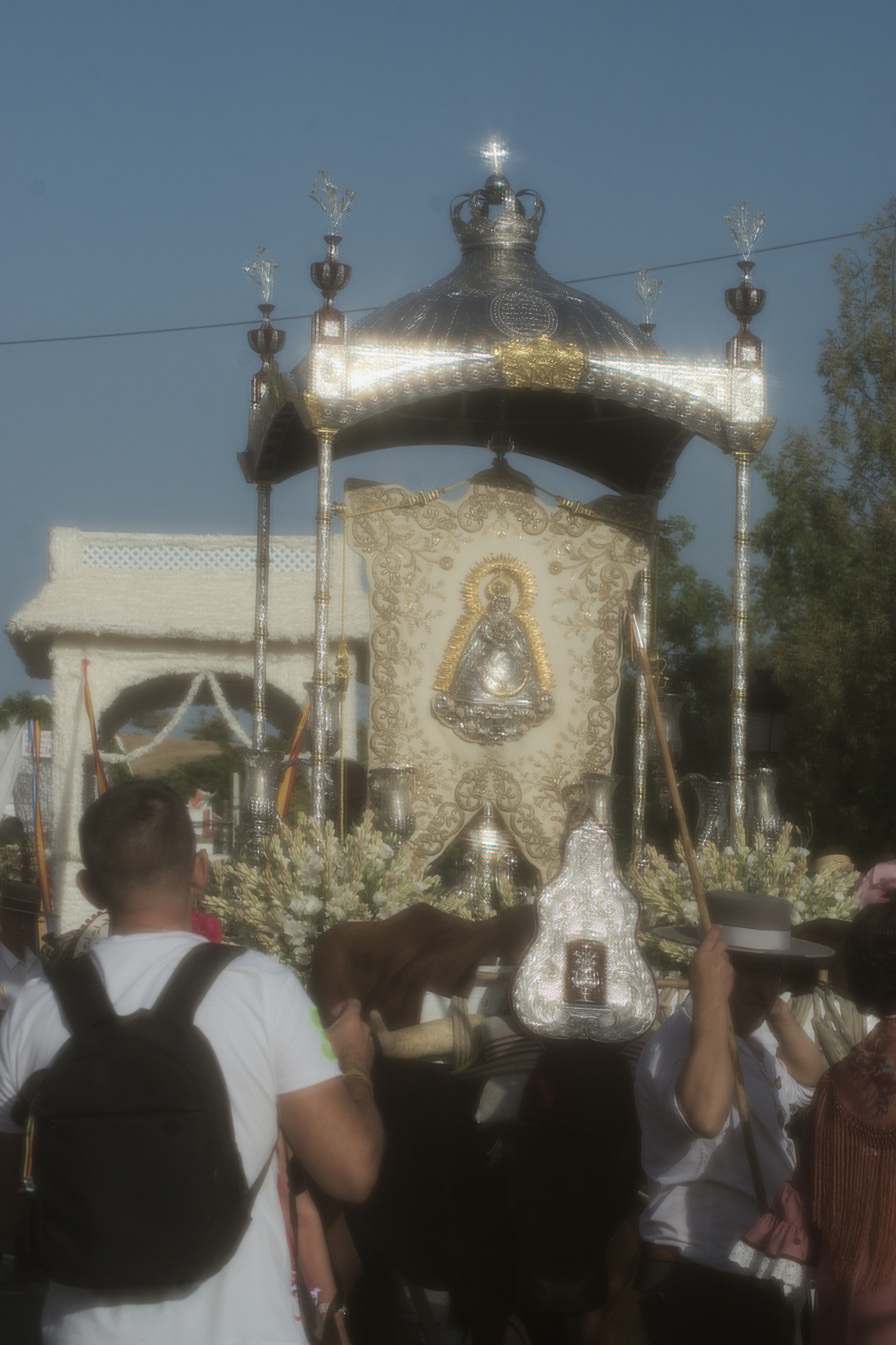 A silver religious float with an embroidered banner during a procession in Spain