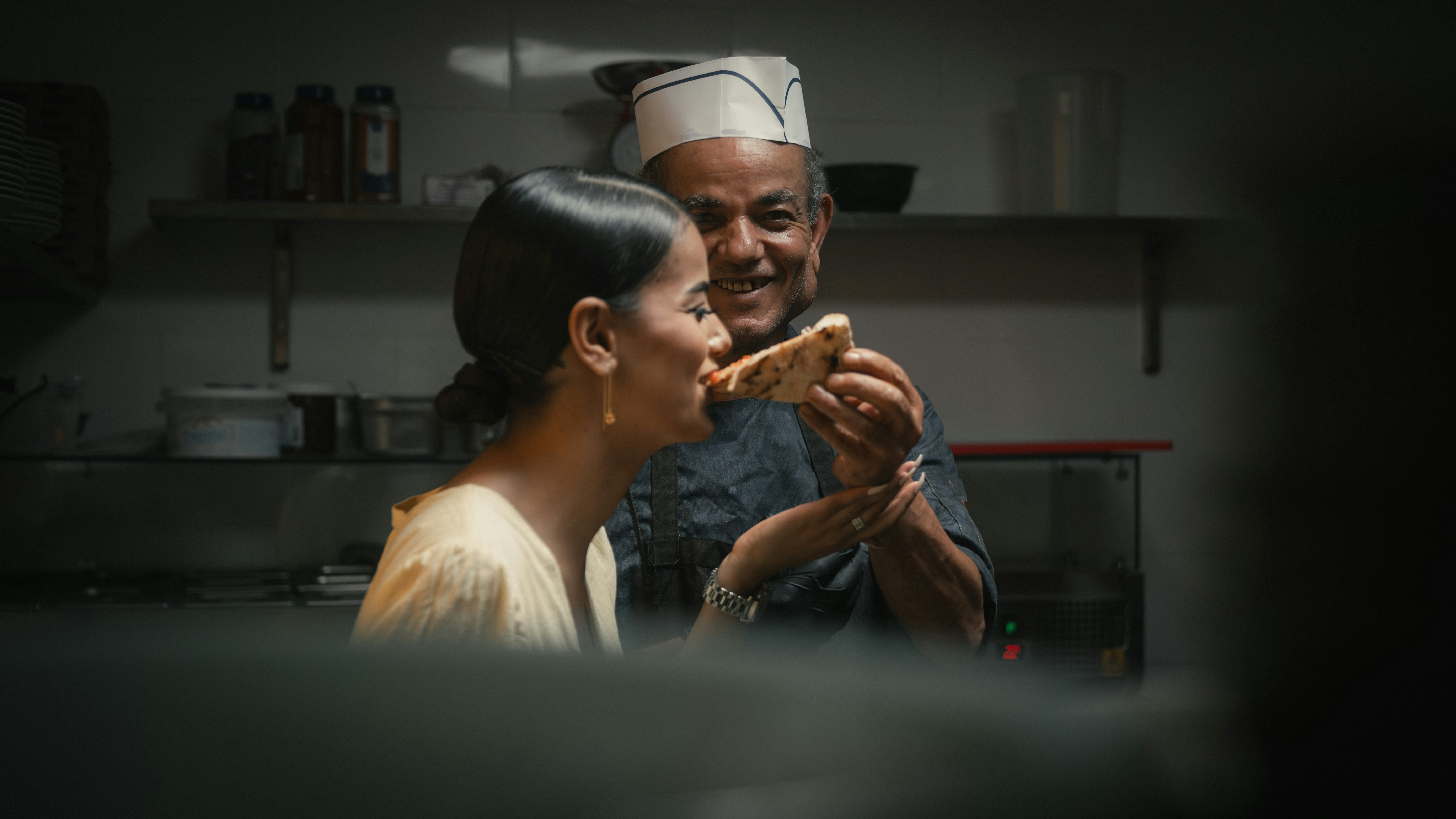 Un chef souriant dans une cuisine de restaurant.