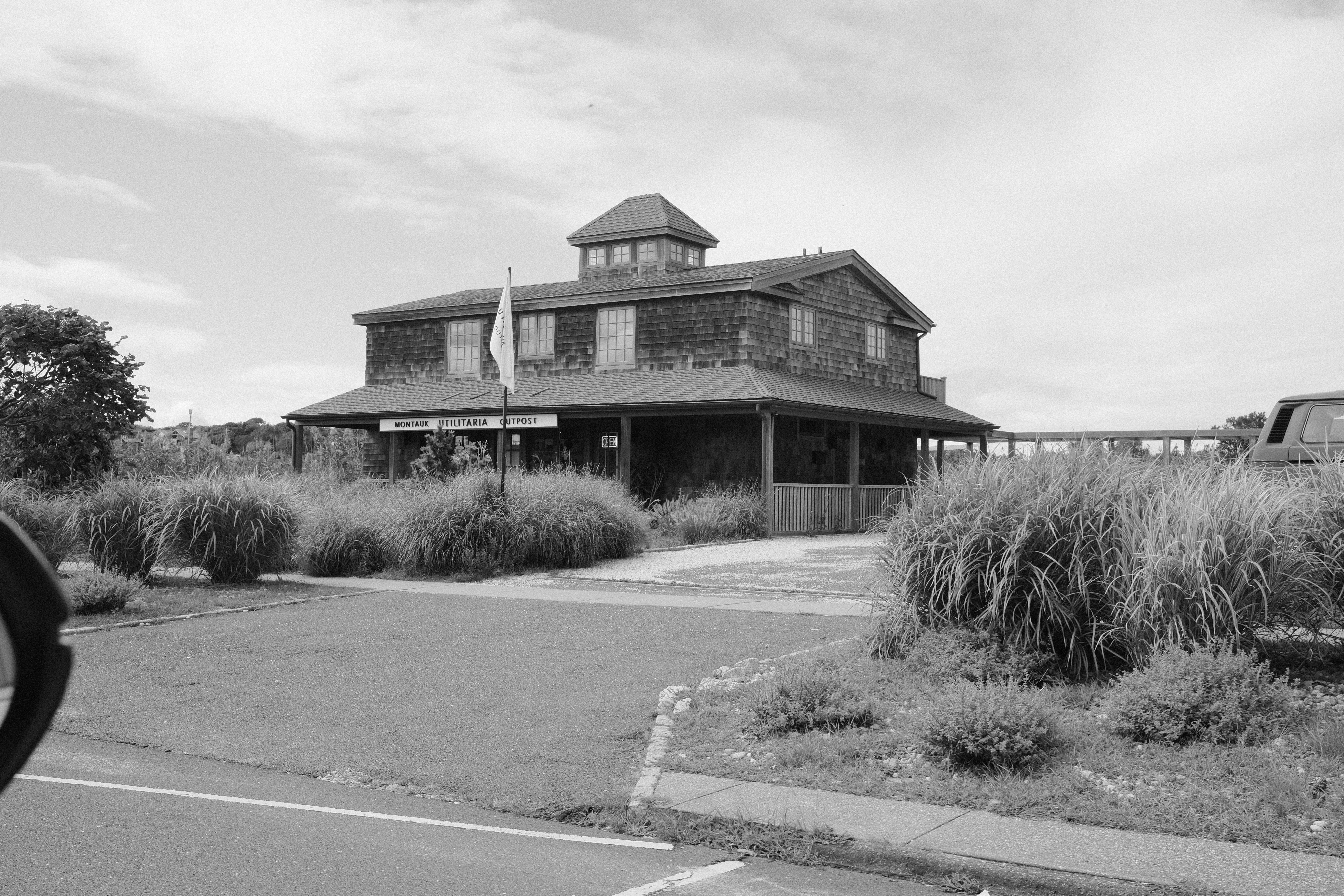 Um edifício de telhas com uma cúpula e uma placa dizendo "POSTO DE UTILIDADE DE MONTAUK em Montauk