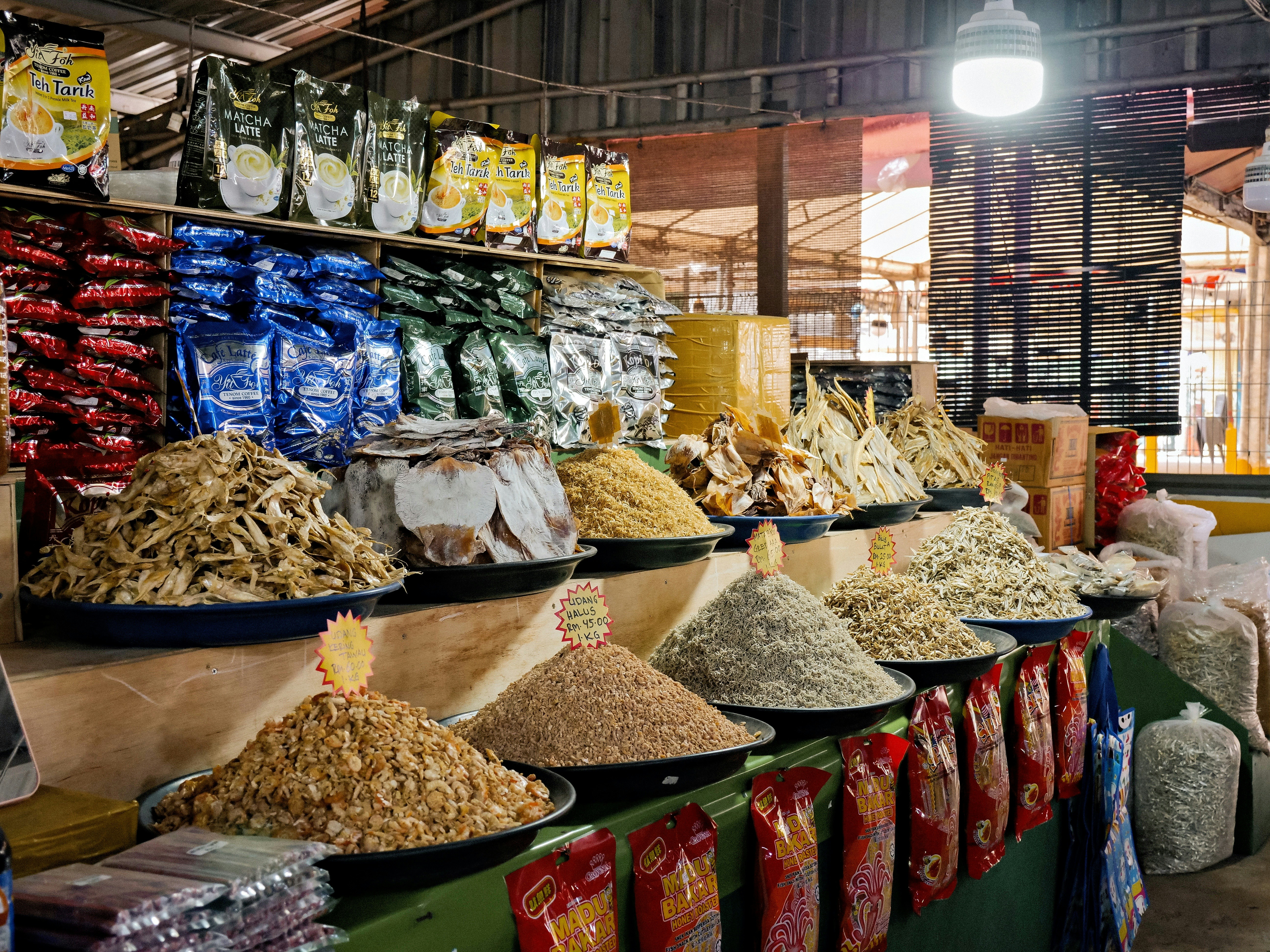 Piles of dried seafood and snacks on display at a market stall