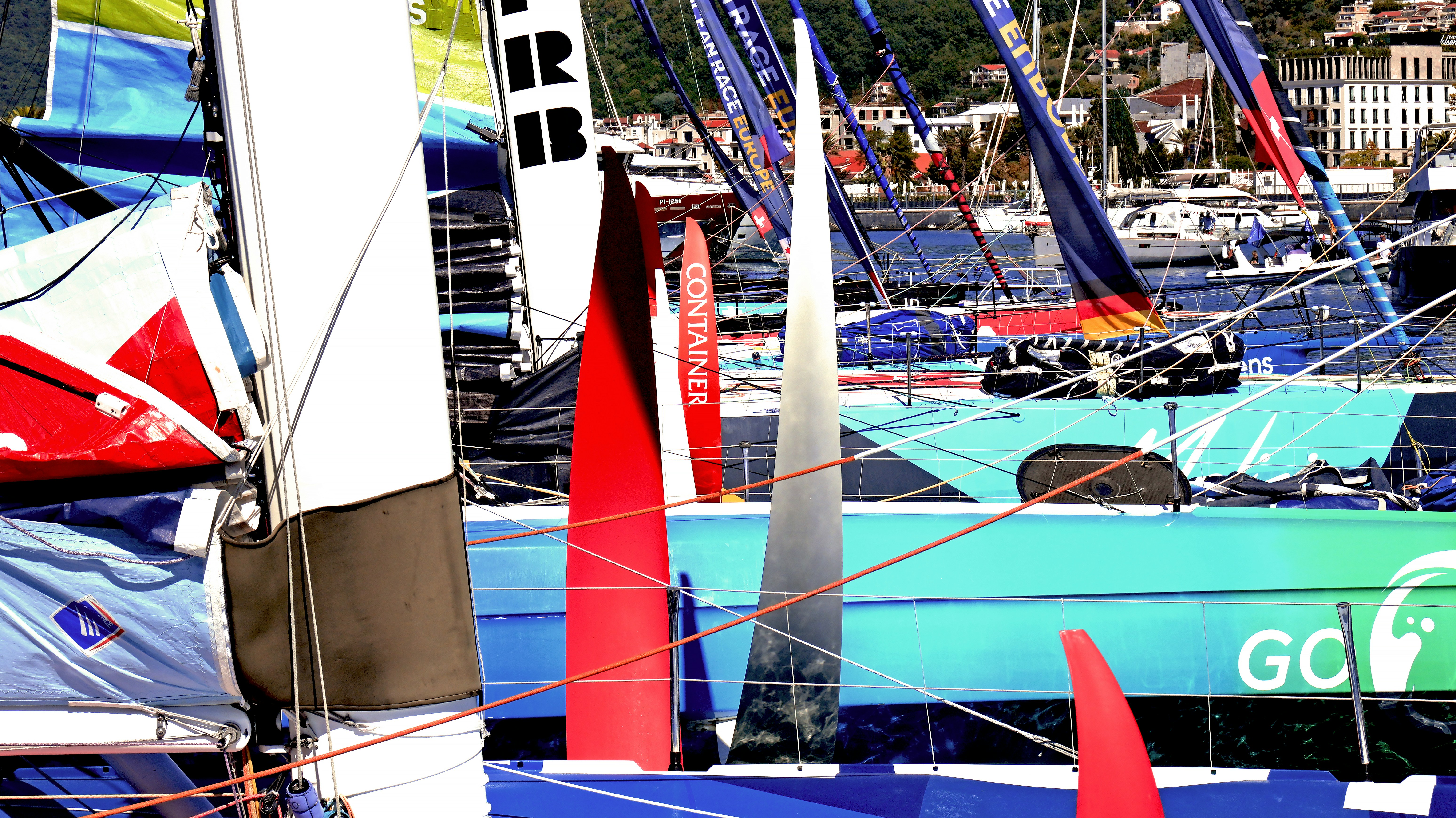 Colorful racing sailboats moored at a marina with masts and rigging visible