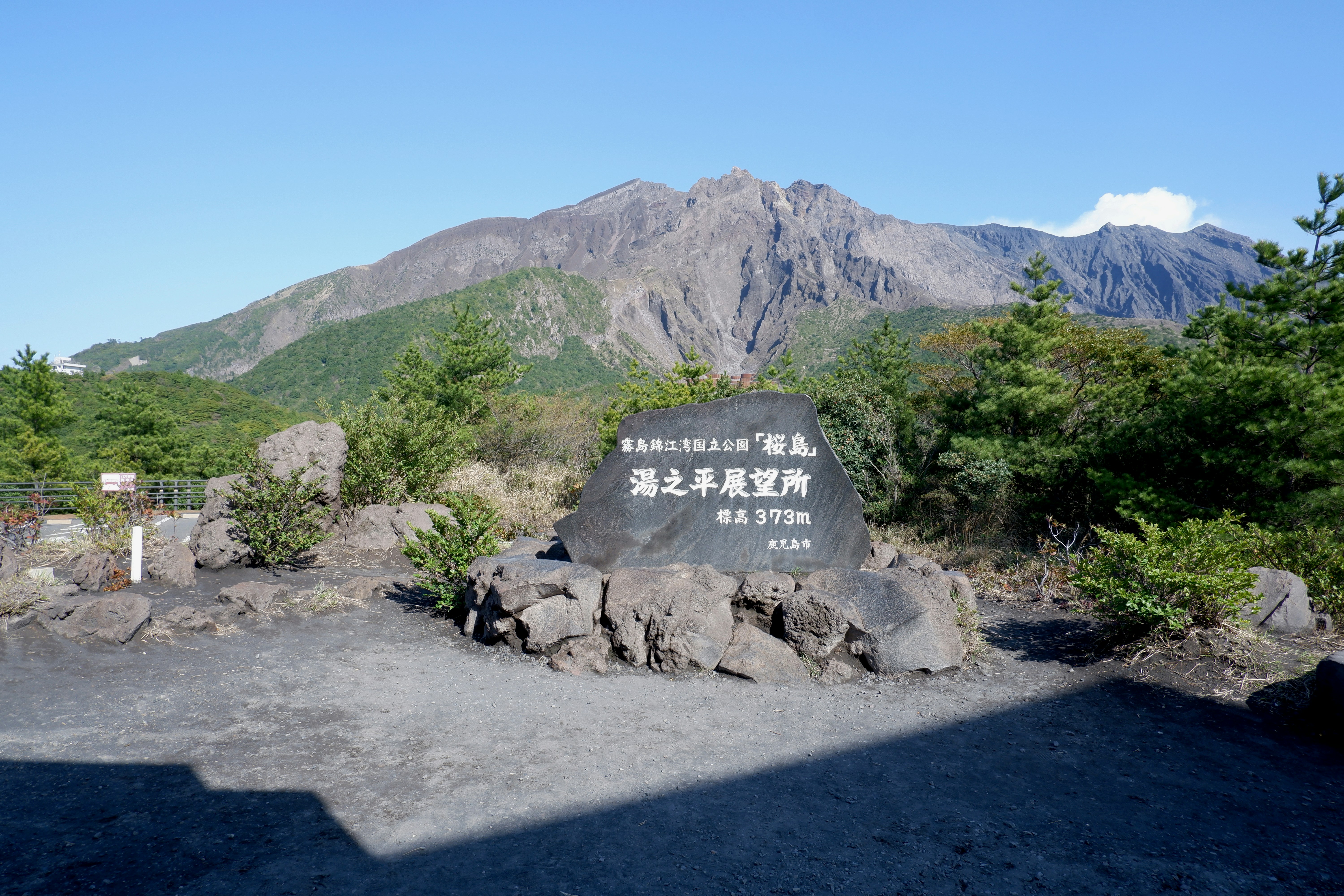A stone monument at the Yunohira Observatory with Sakurajima volcano in the background