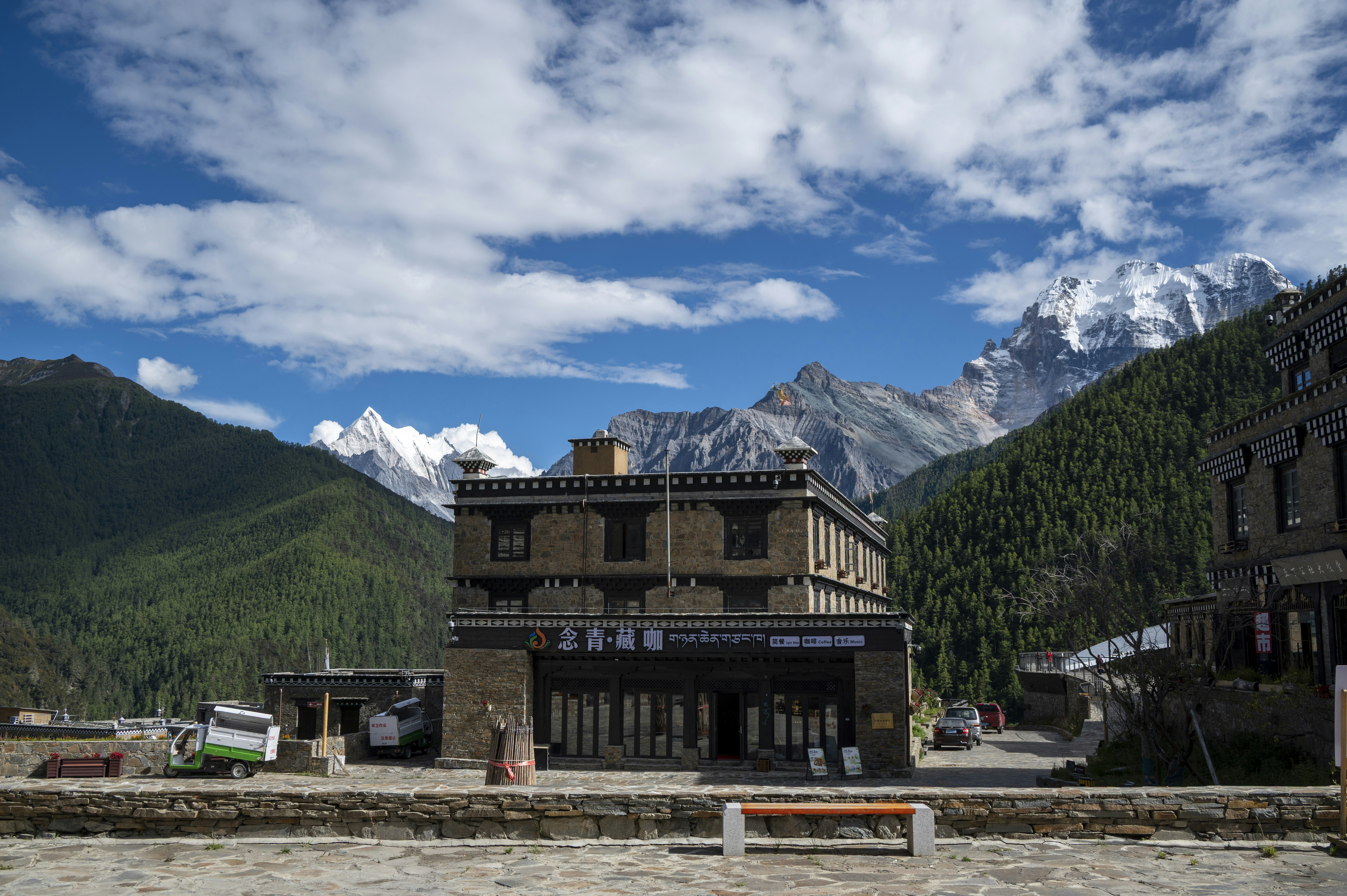 A stone building with a cafe in a mountain valley under a blue sky