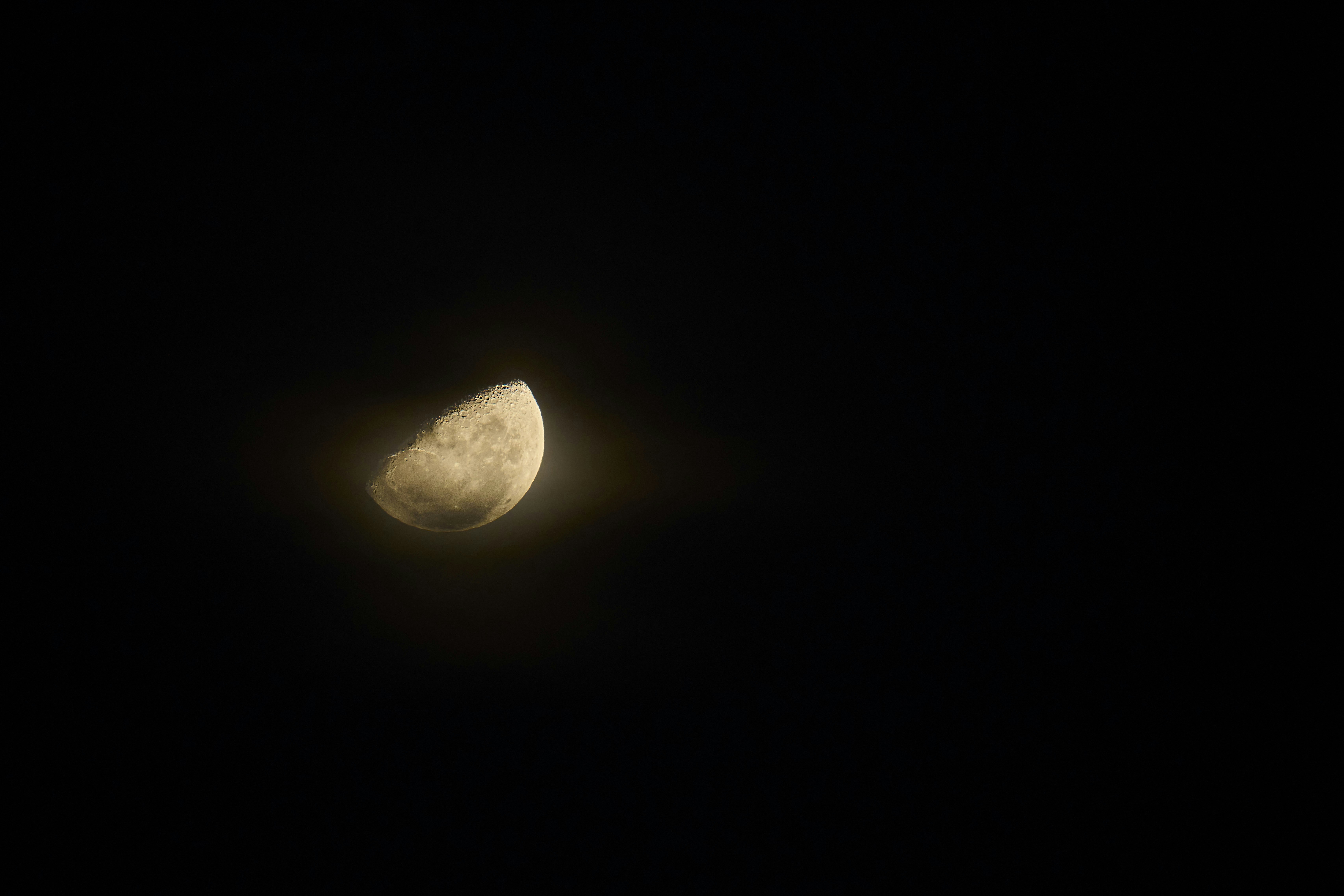 A glowing crescent moon against a deep black night sky