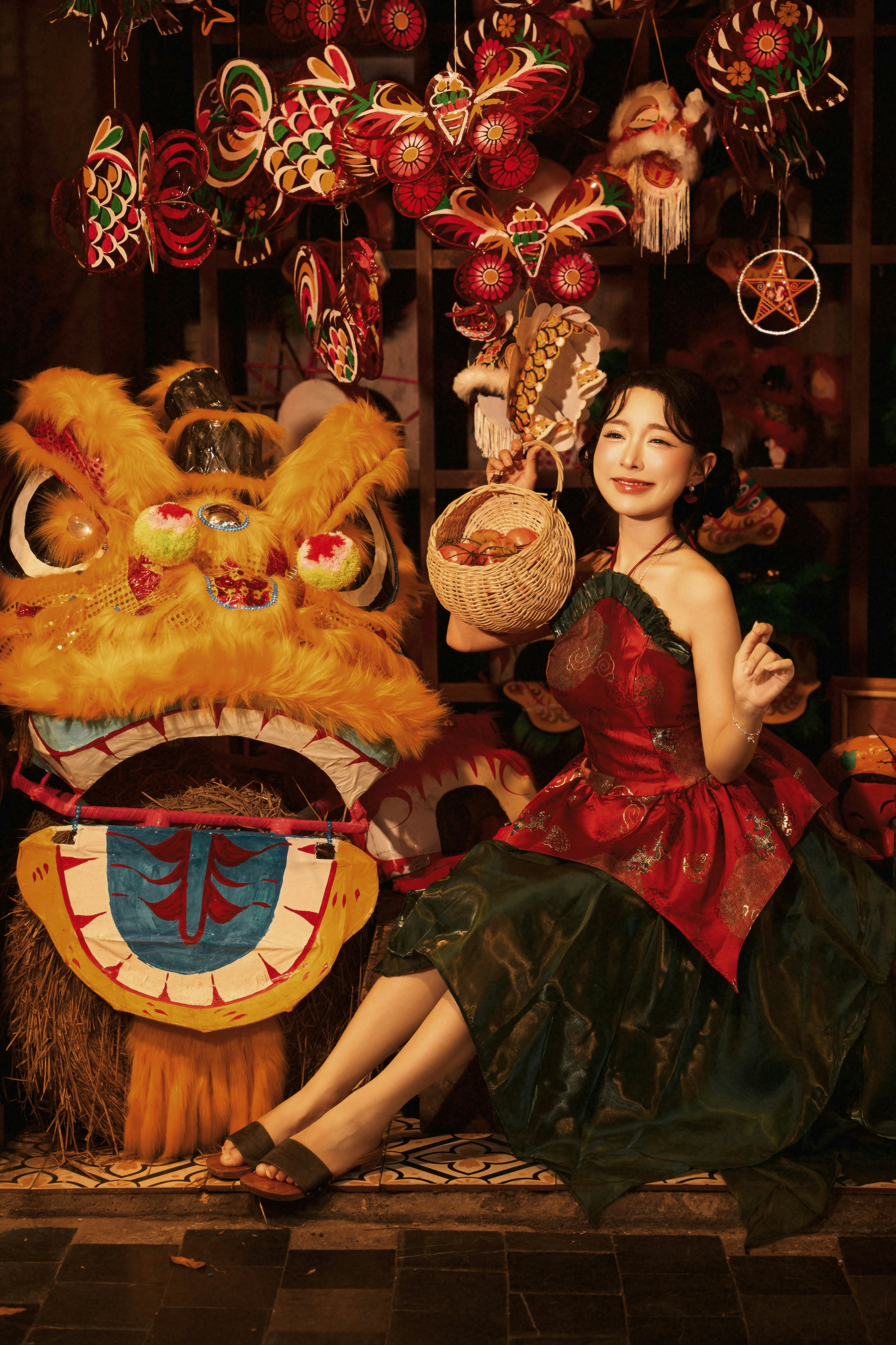 A woman holding a basket beside a large lion dance costume among lanterns