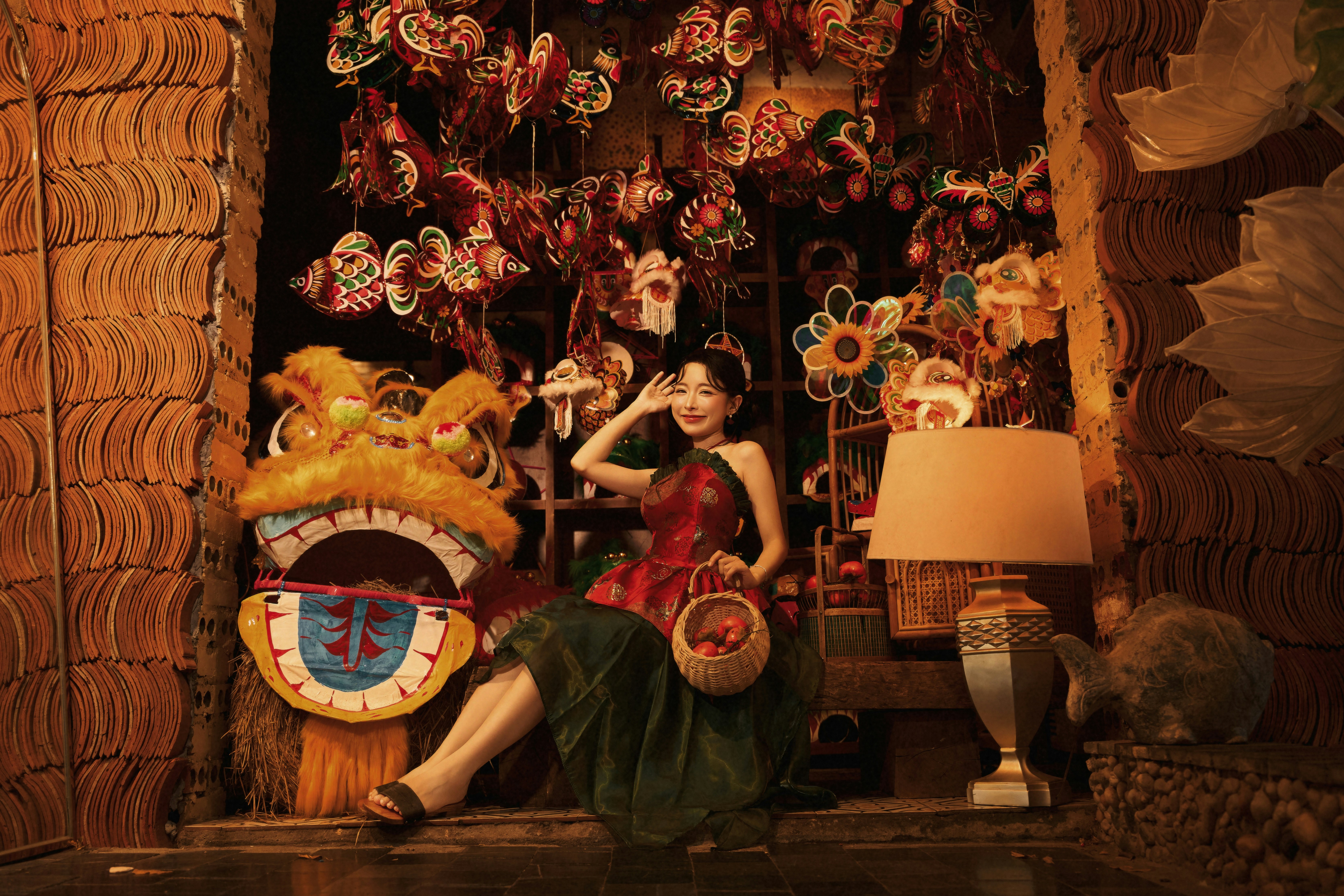 A woman in a red top and green skirt holding a basket near lion masks