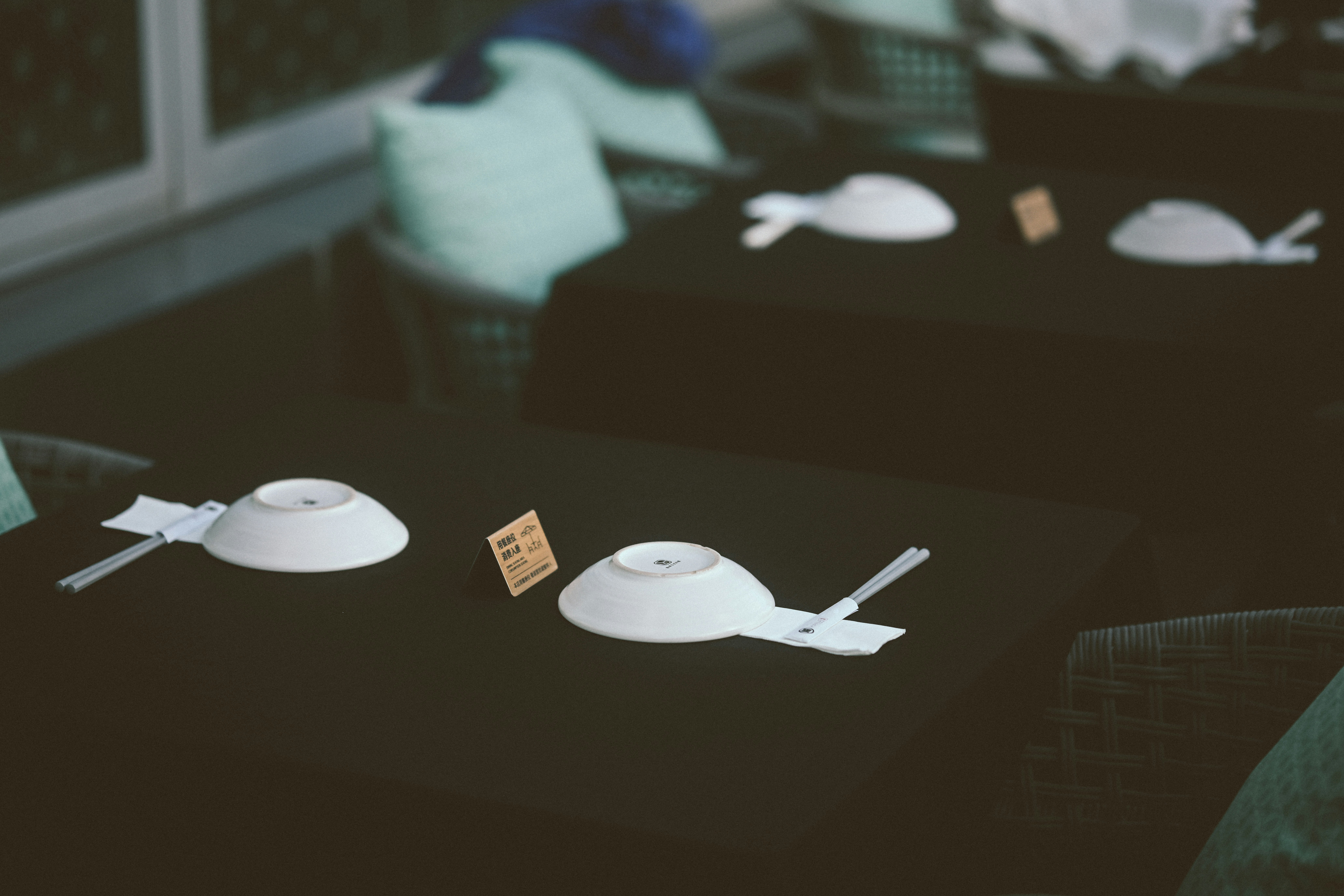 White bowls and chopsticks on a black table