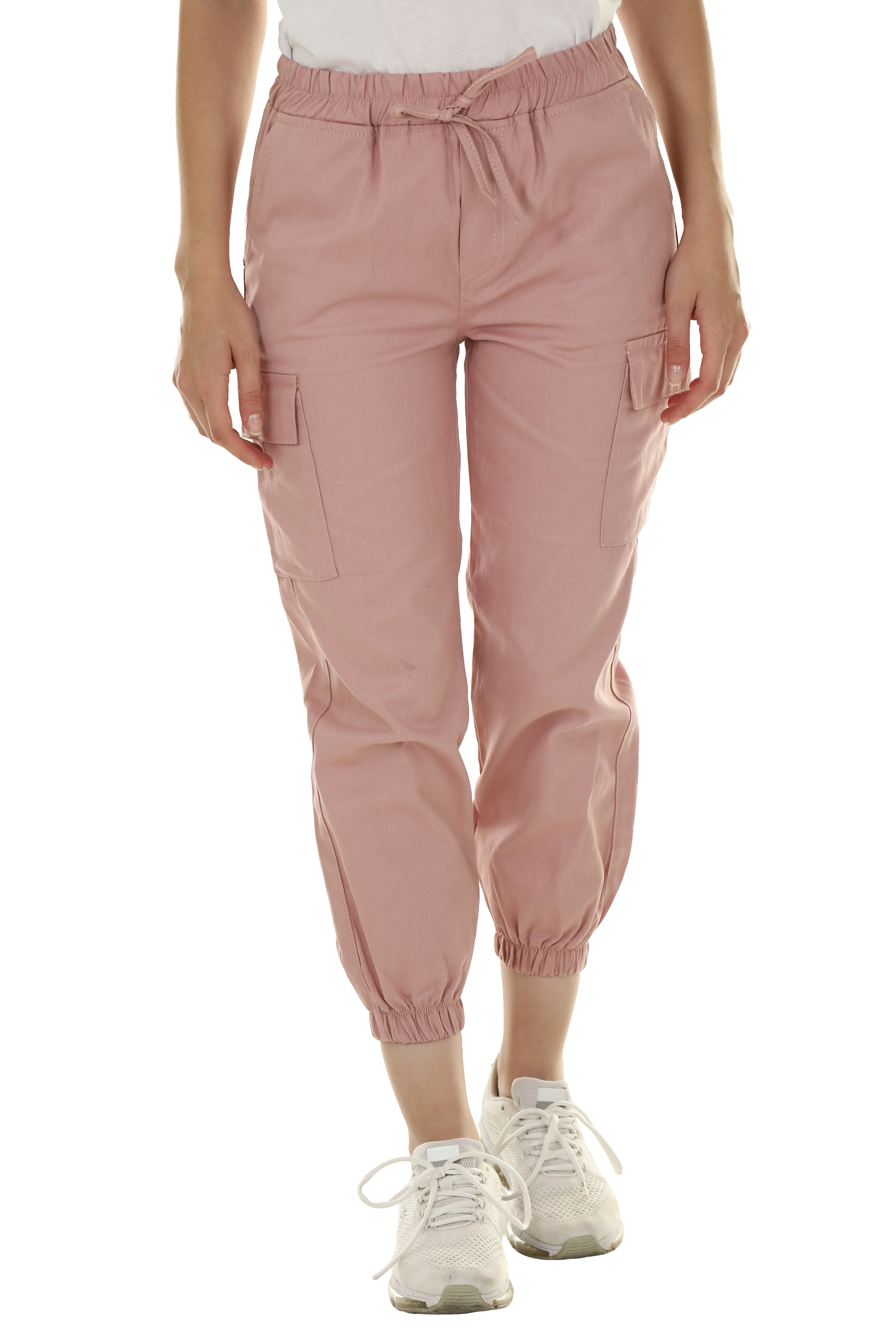 A person wearing pink cargo joggers with a drawstring waist and white sneakers