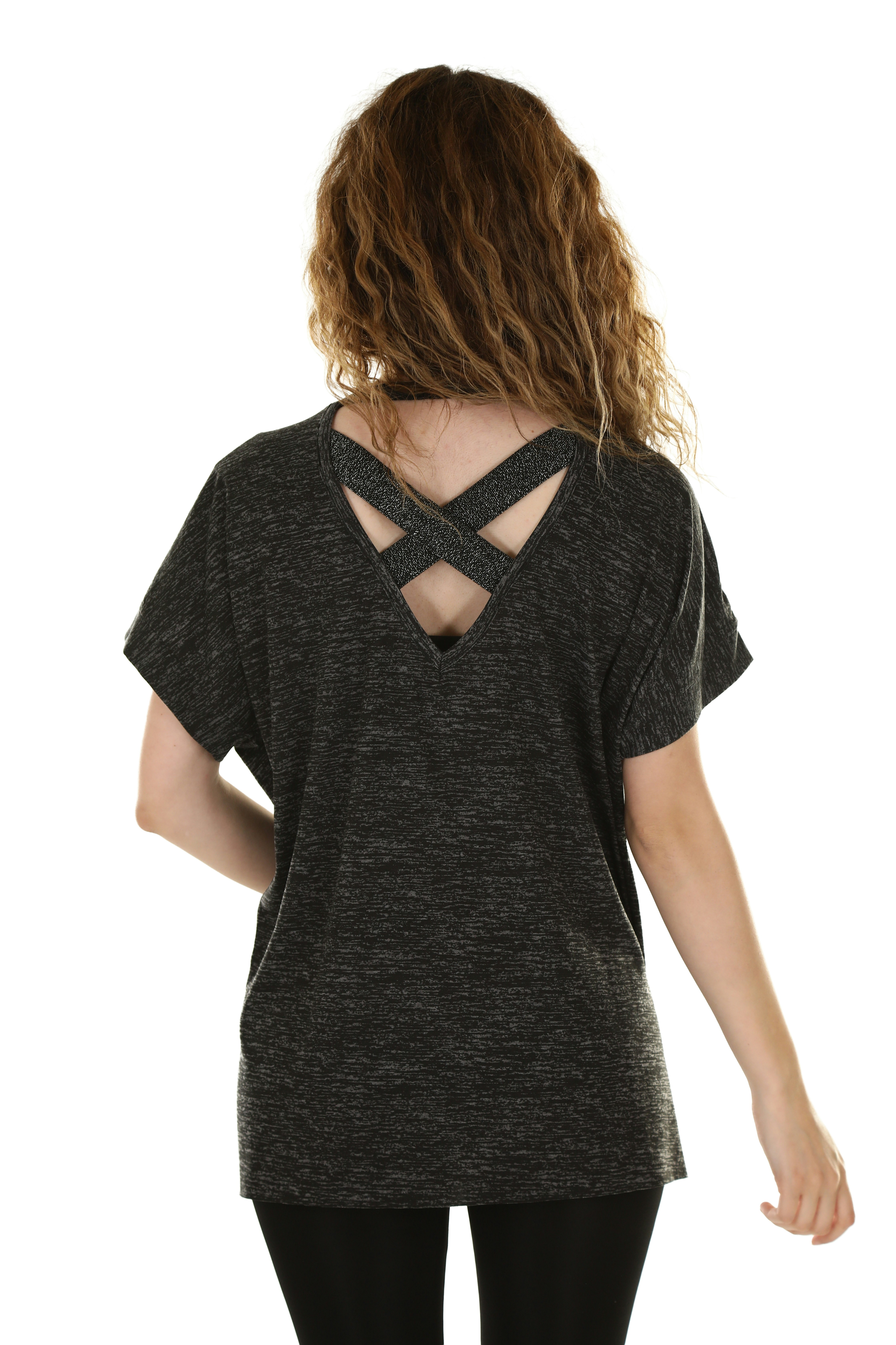 A woman with curly hair wearing a grey marl top with crisscross back straps