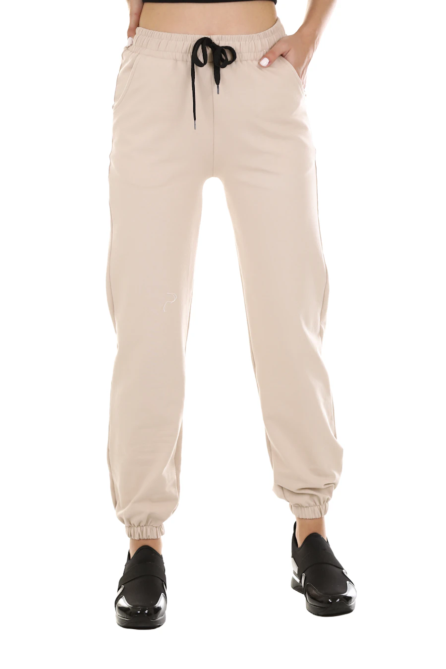 Beige sweatpants with a black drawcord and cuffed ankles