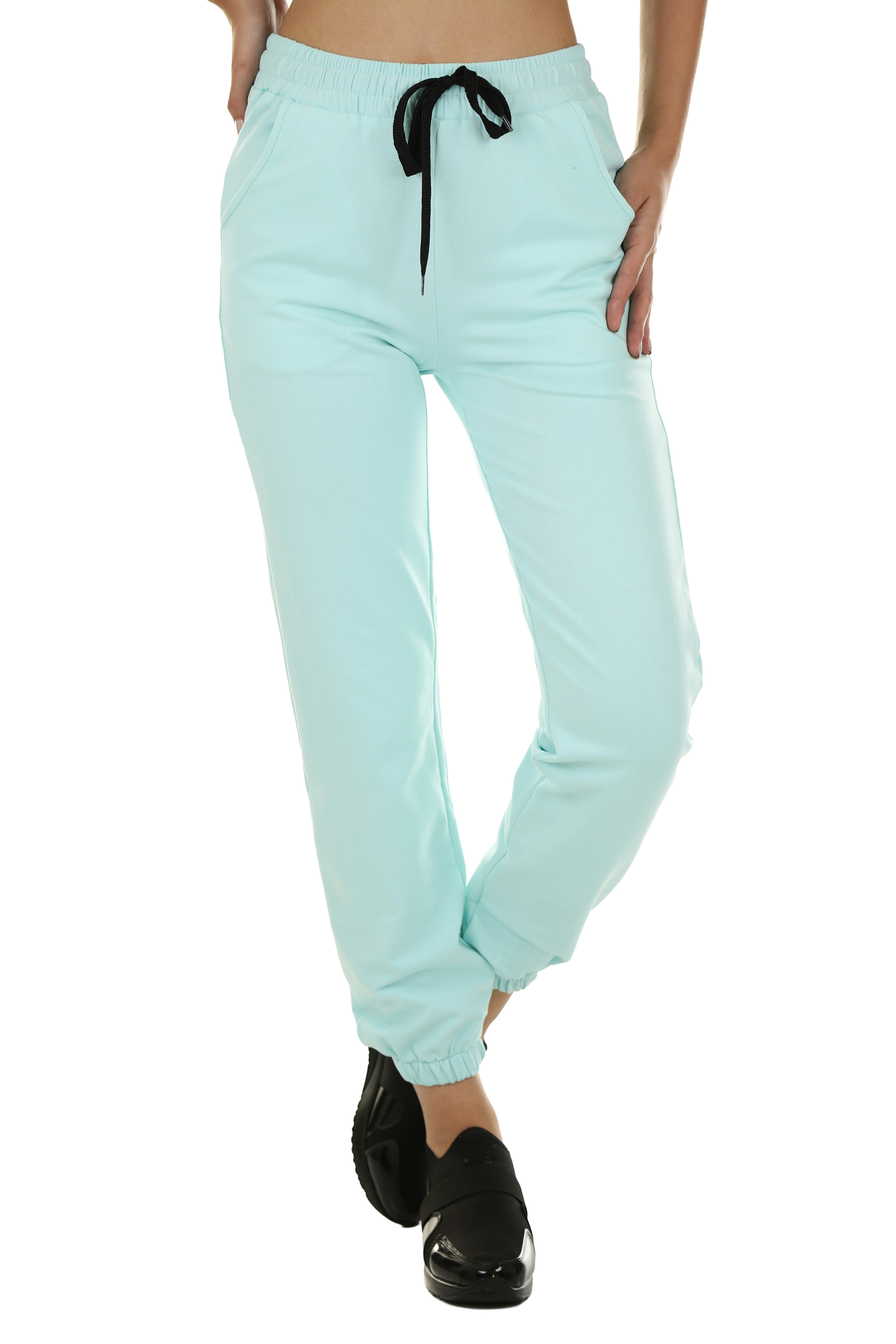 A person wearing light blue sweatpants with a black drawstring and black shoes