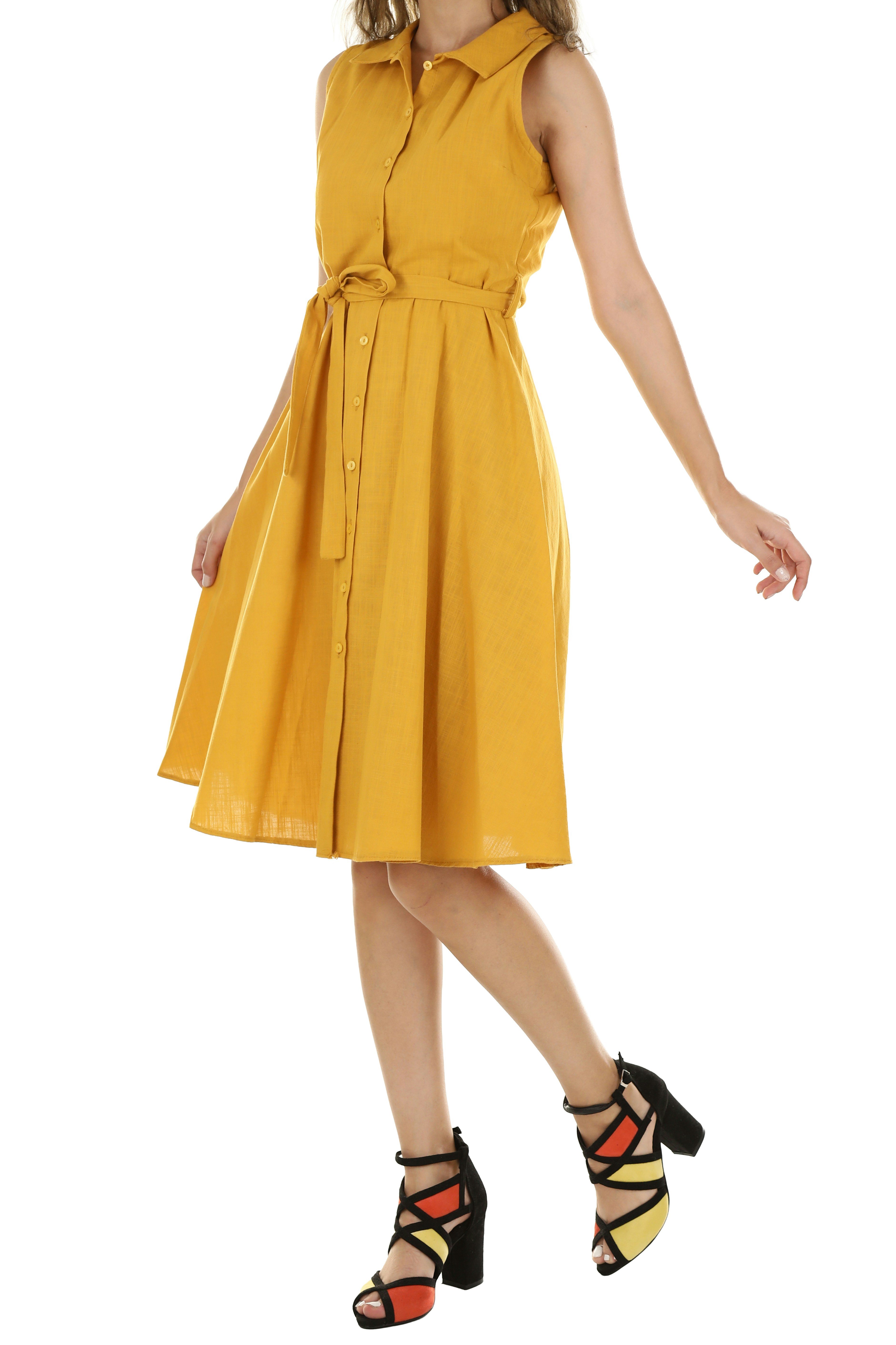 A person wearing a sleeveless yellow button-down dress with a tie waist