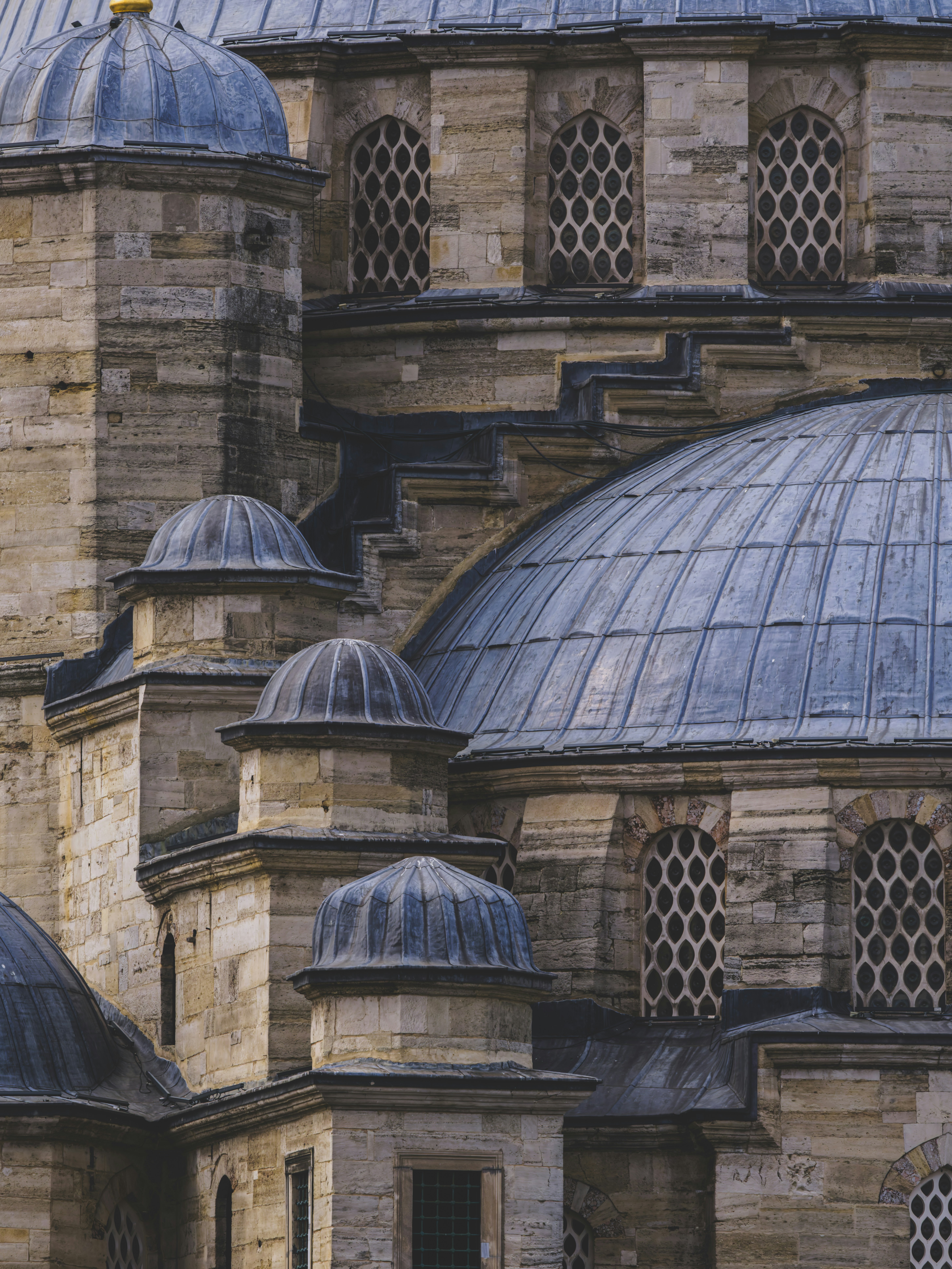 Stone domes and arched windows of a historic mosque in Istanbul, Türkiye