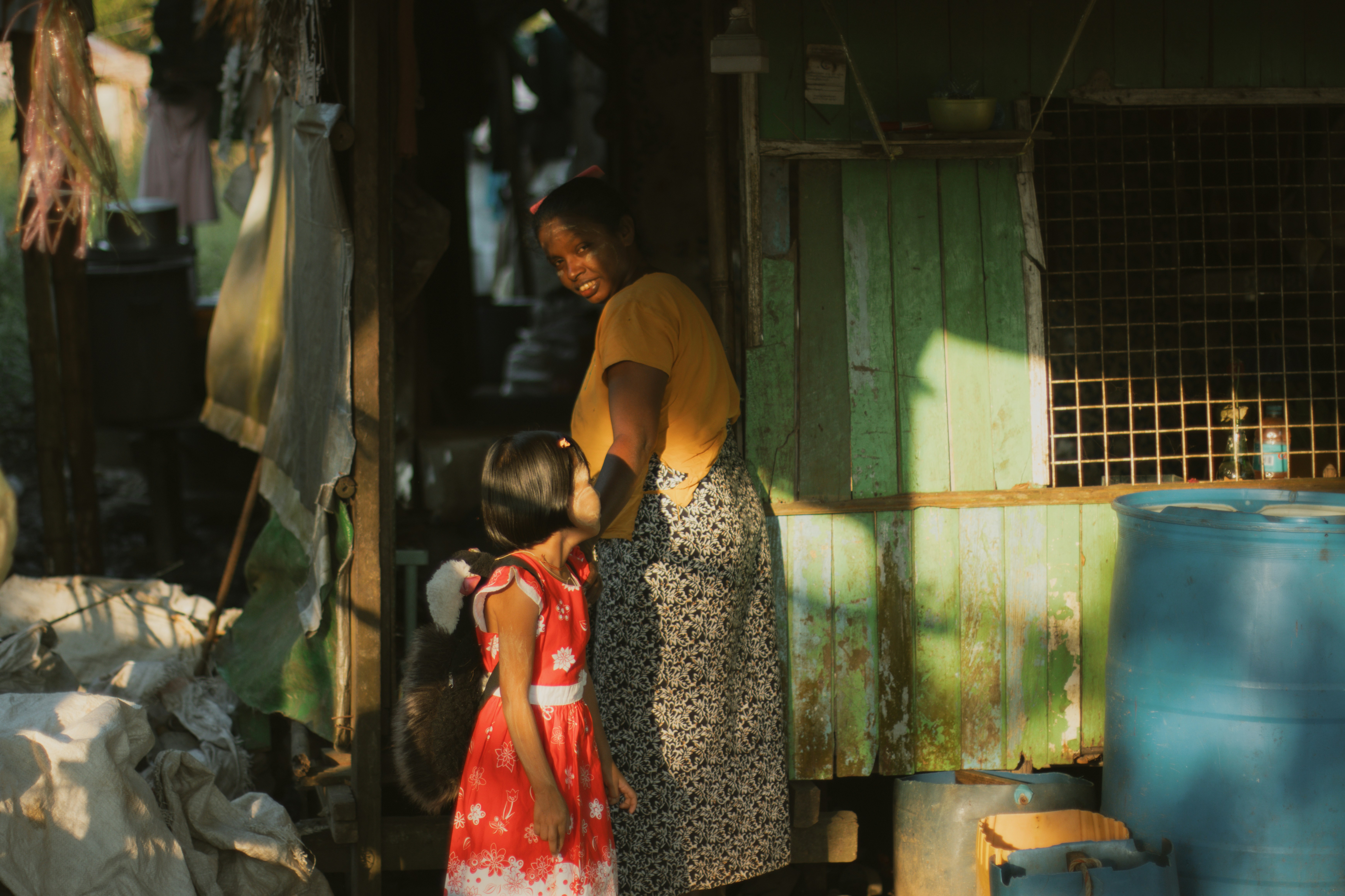 A woman in a yellow shirt and a child in a red dress