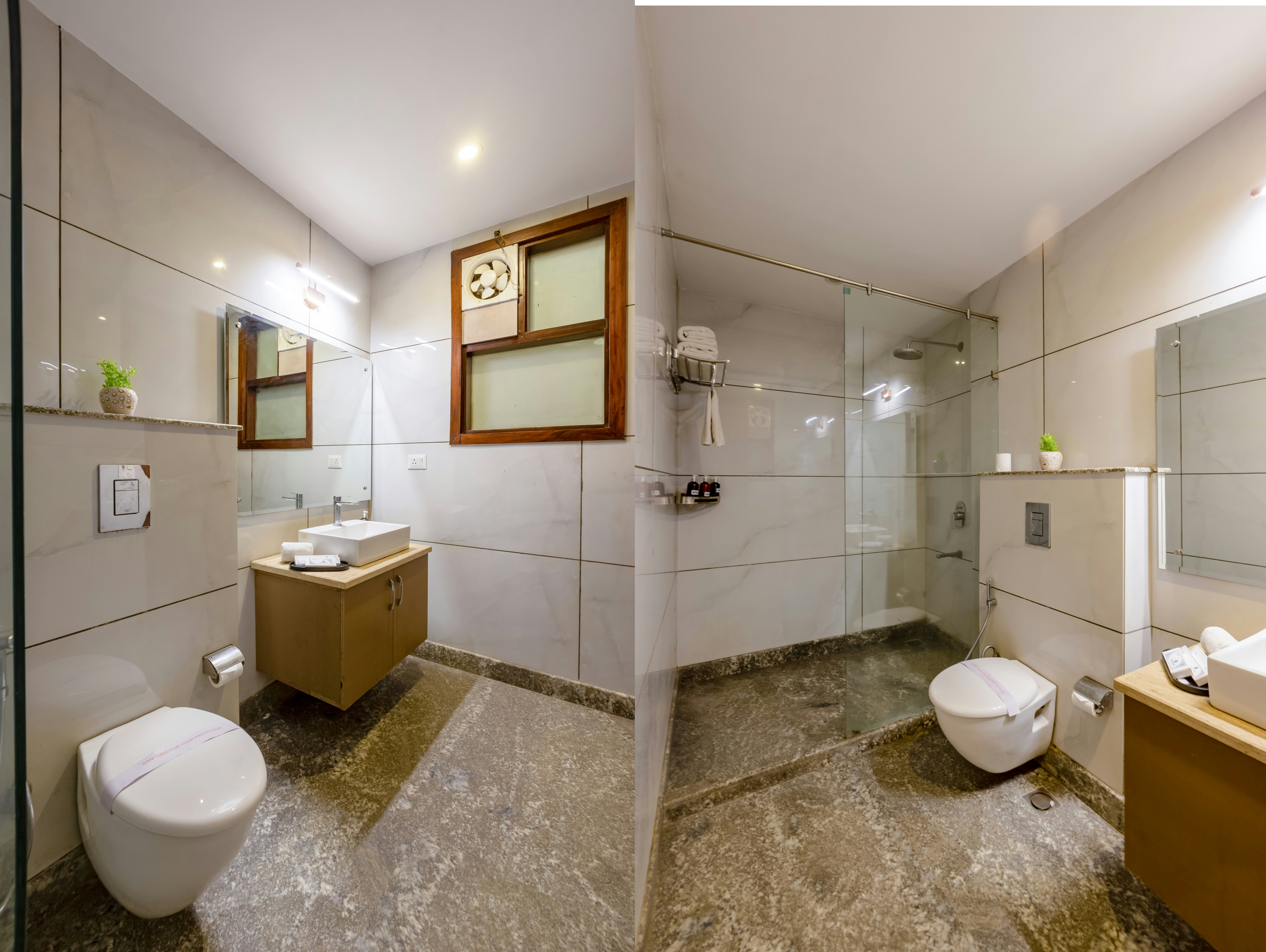 Kamar mandi berdinding keramik putih dengan bilik shower kaca dan wastafel