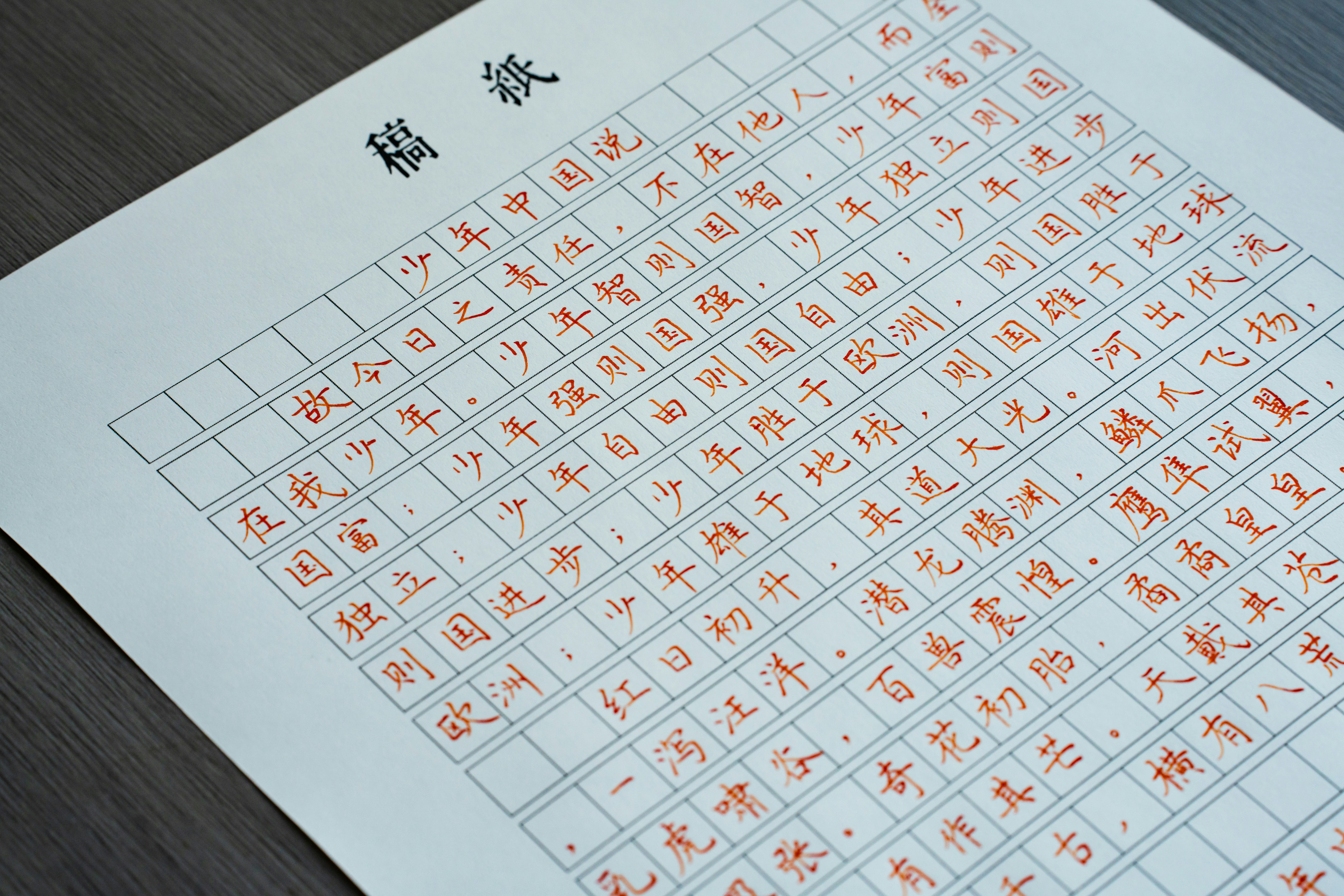 Handwritten Chinese characters in red ink on a grid paper manuscript sheet
