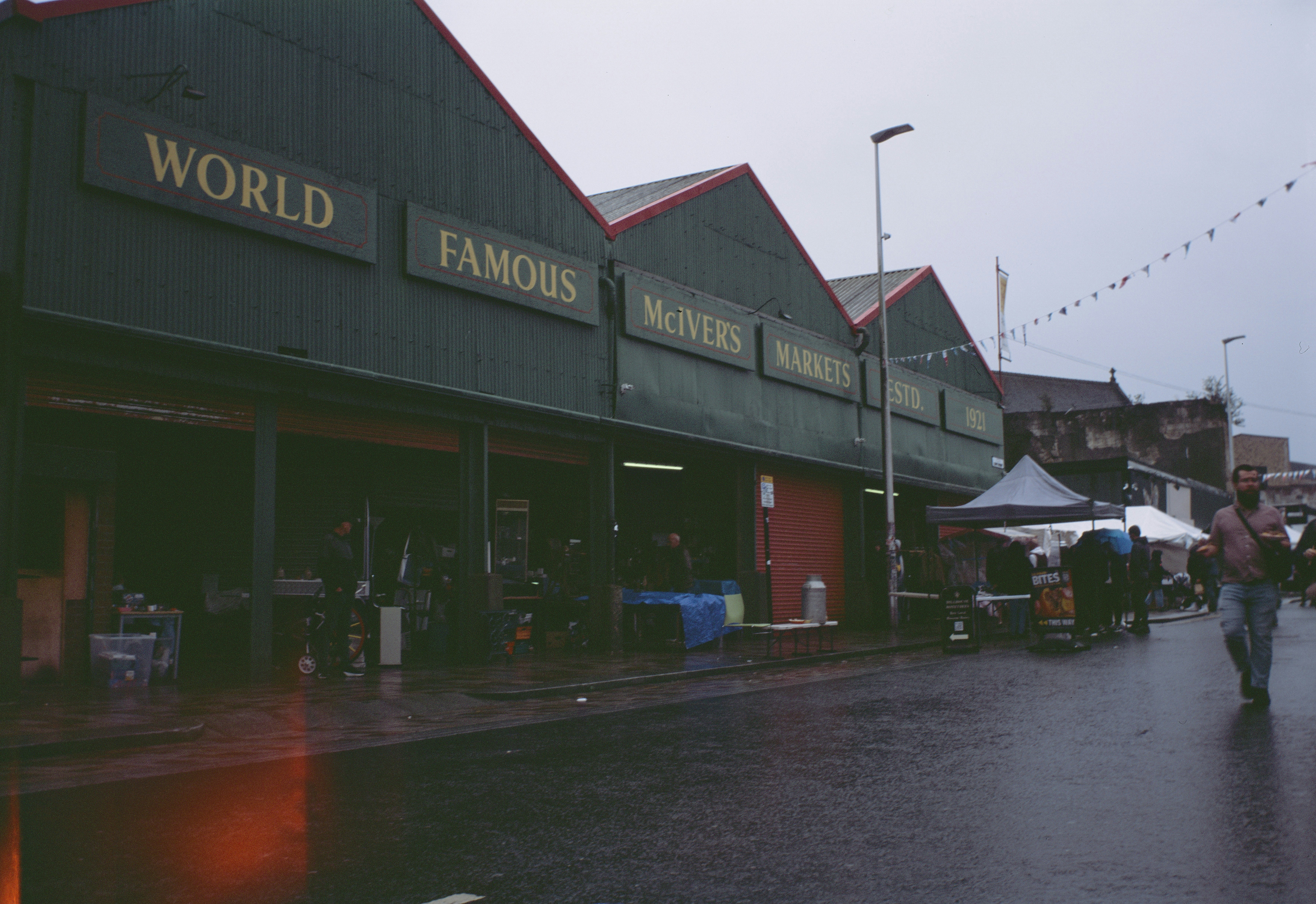 People walking past McIver's Markets in Glasgow on a rainy day