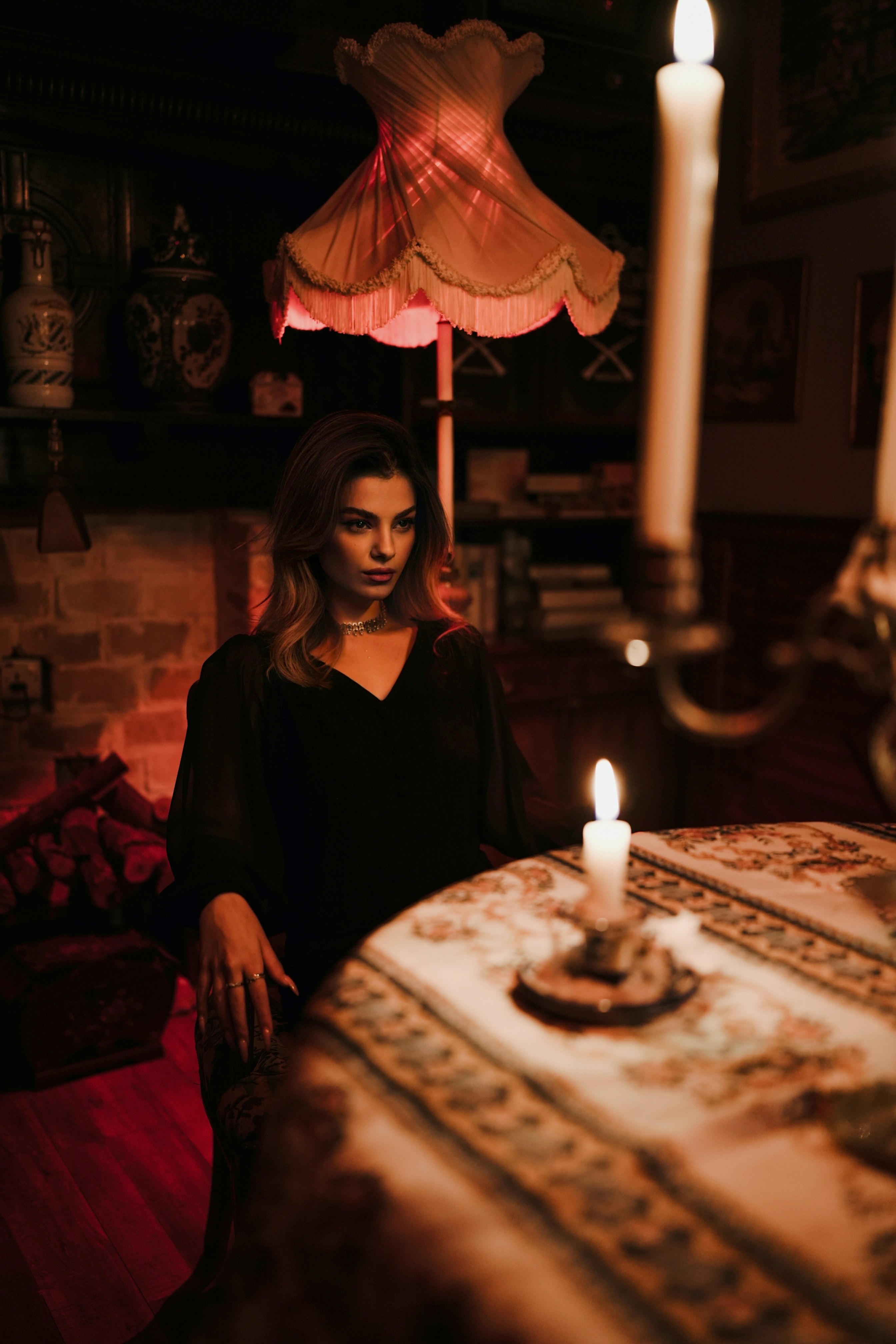 A woman in a black dress sitting at a table with a lit candle - 相关推荐