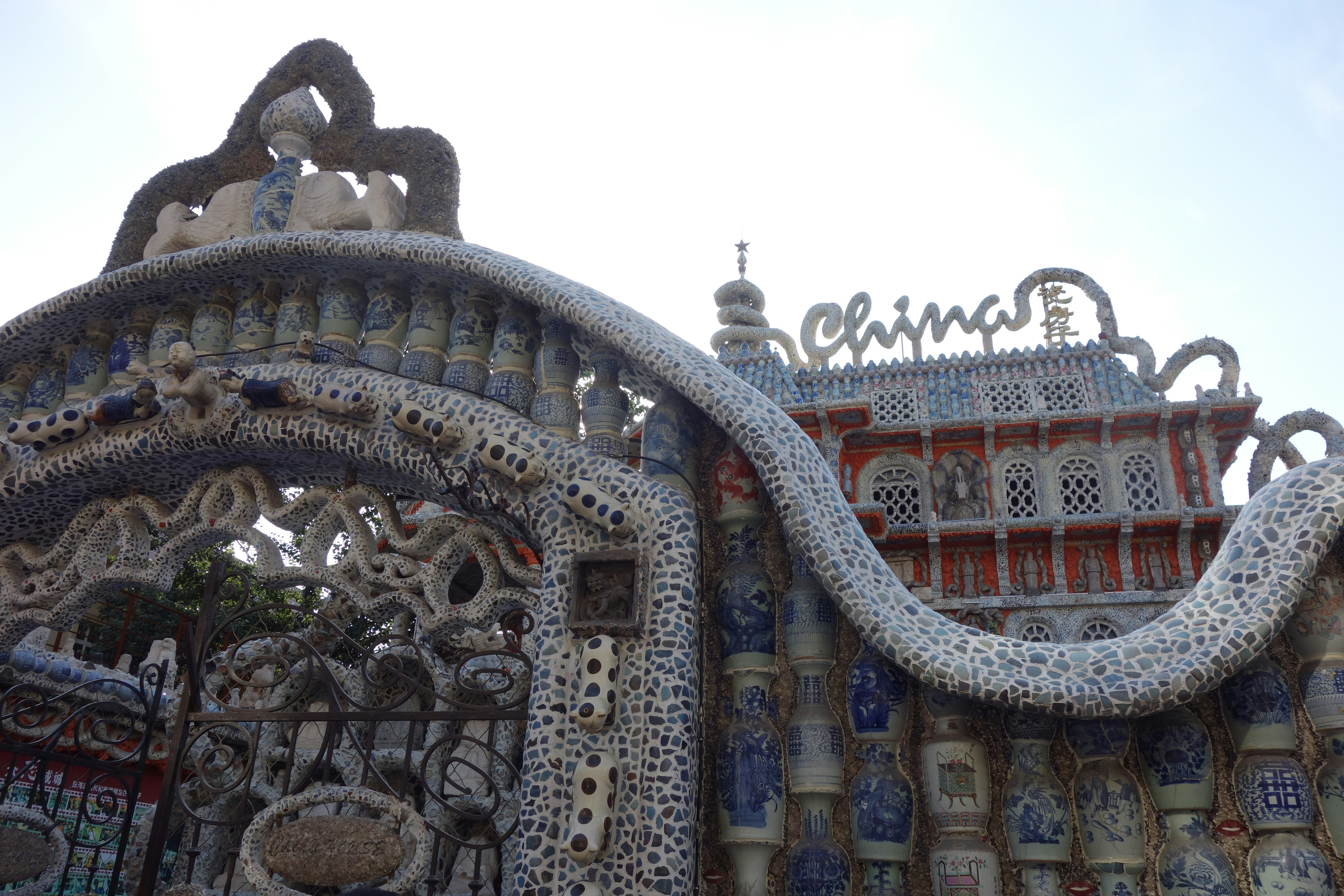 Um arco ornamentado e fachada do edifício decorados com cacos de porcelana azul e branca