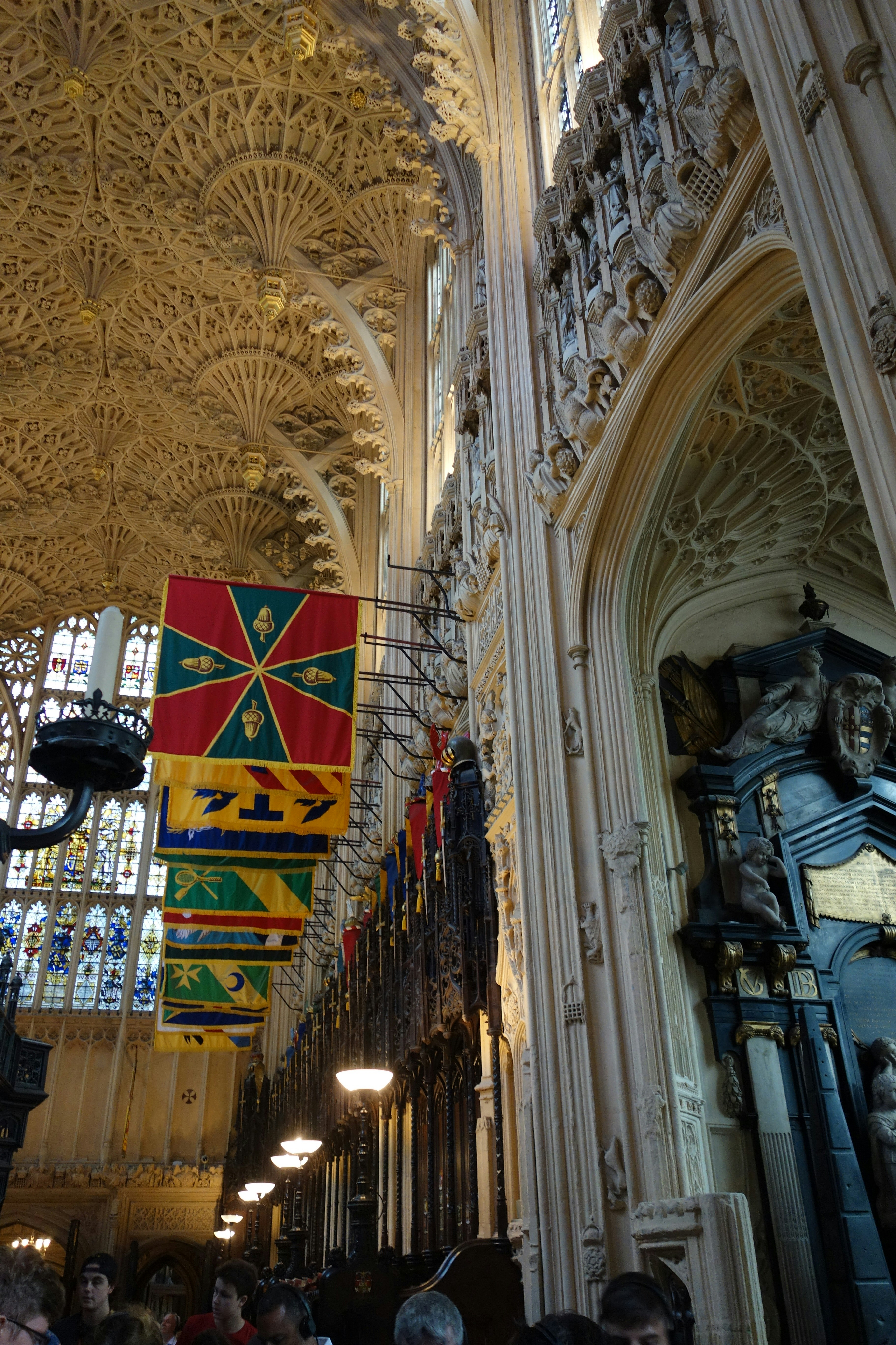 Bandeiras coloridas penduradas no teto ornamentado abobadado em leque da Capela do King's College em Cambridge